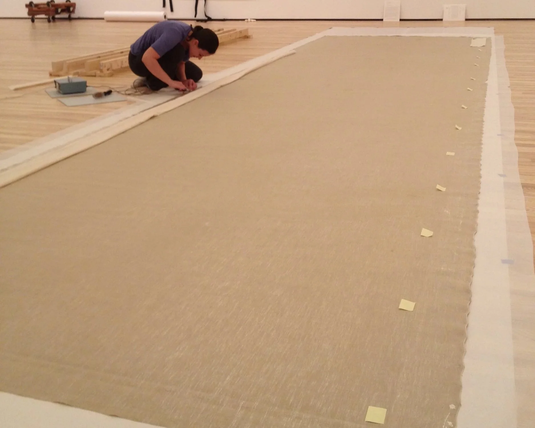 Strip-lining an oversized Andy Warhol painting in preparation for stretching - Image courtesy of Mary Sebera