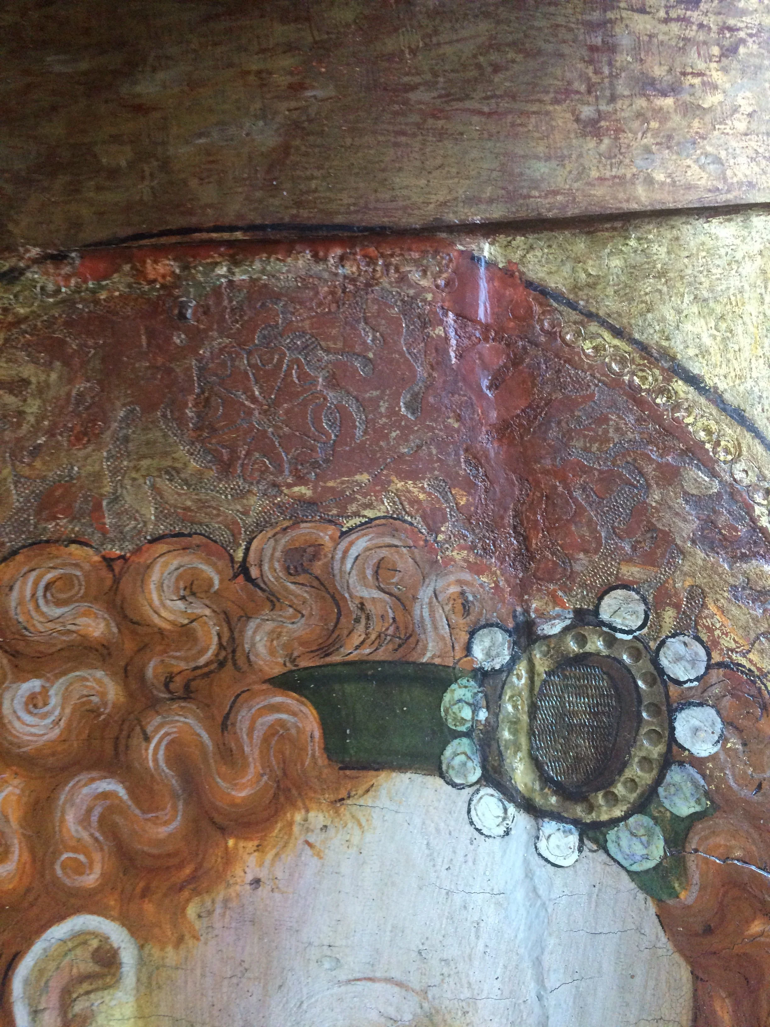 Detail of ornate halo at join in 15th century panel painting during treatment.  Carving a wax fill to mimic the detailed punchwork.