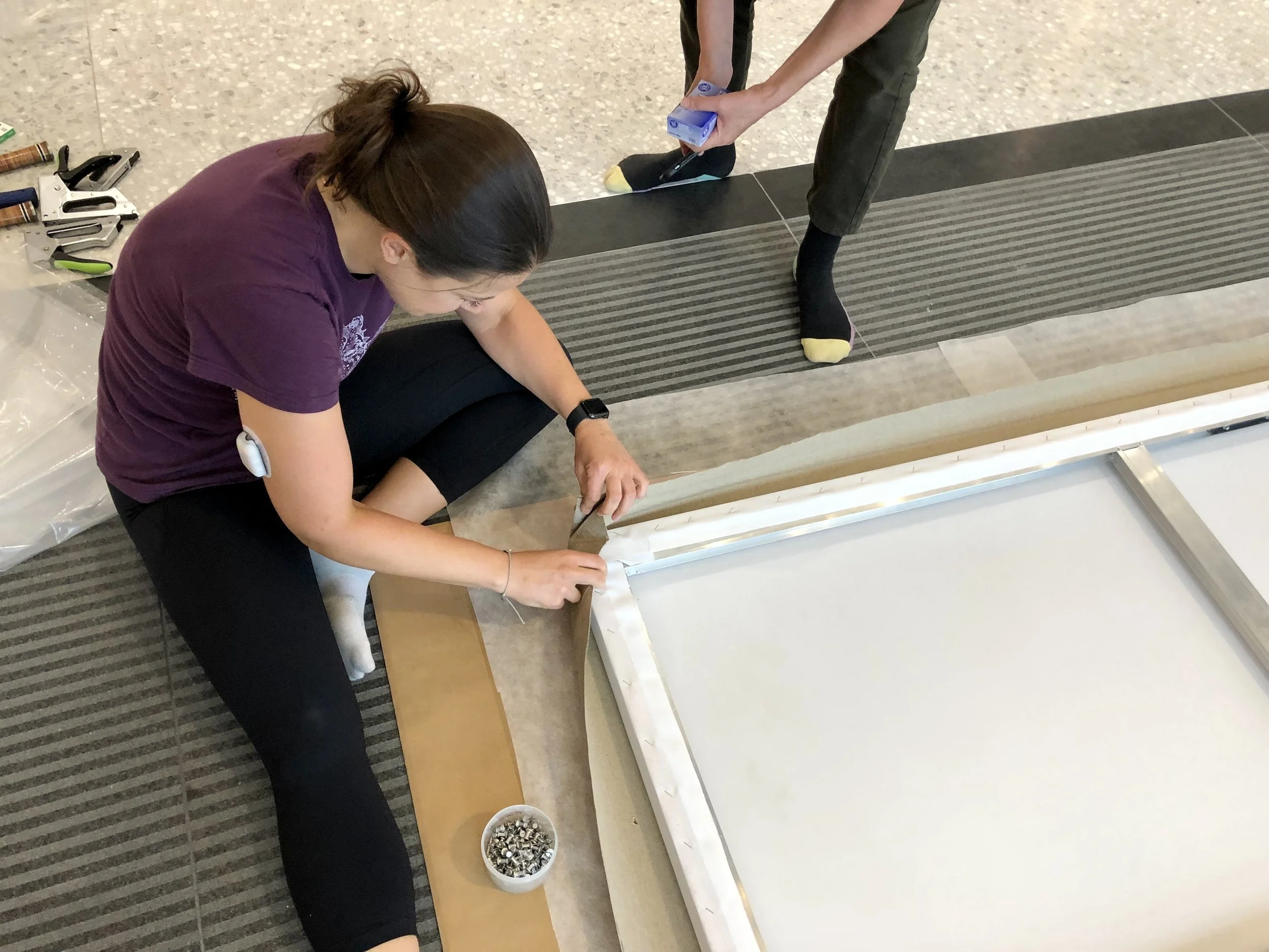 Examining the placement of the canvas on a stretcher before pinning - Image courtesy of Brian Linke