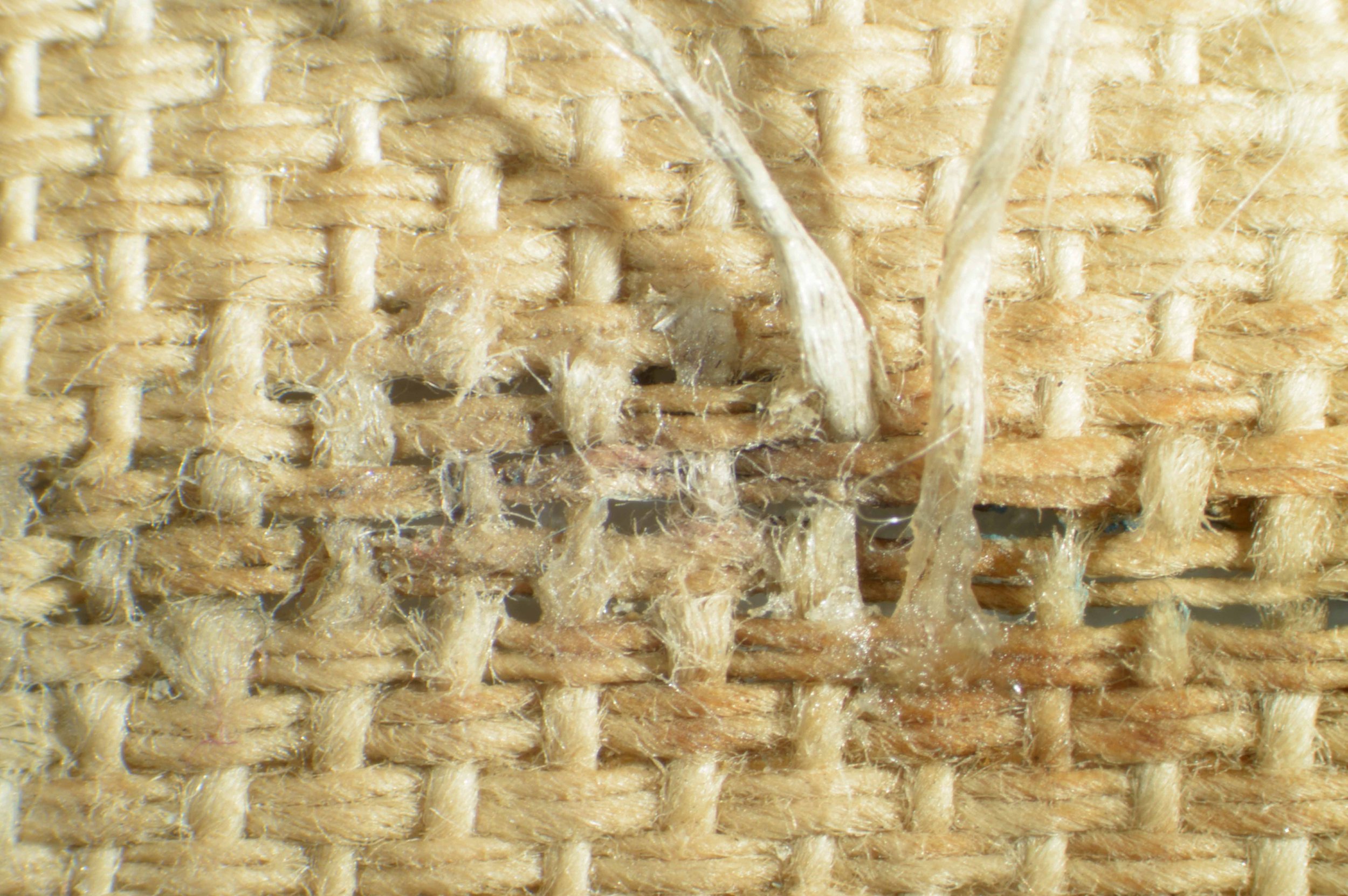 Tear in canvas being rewoven