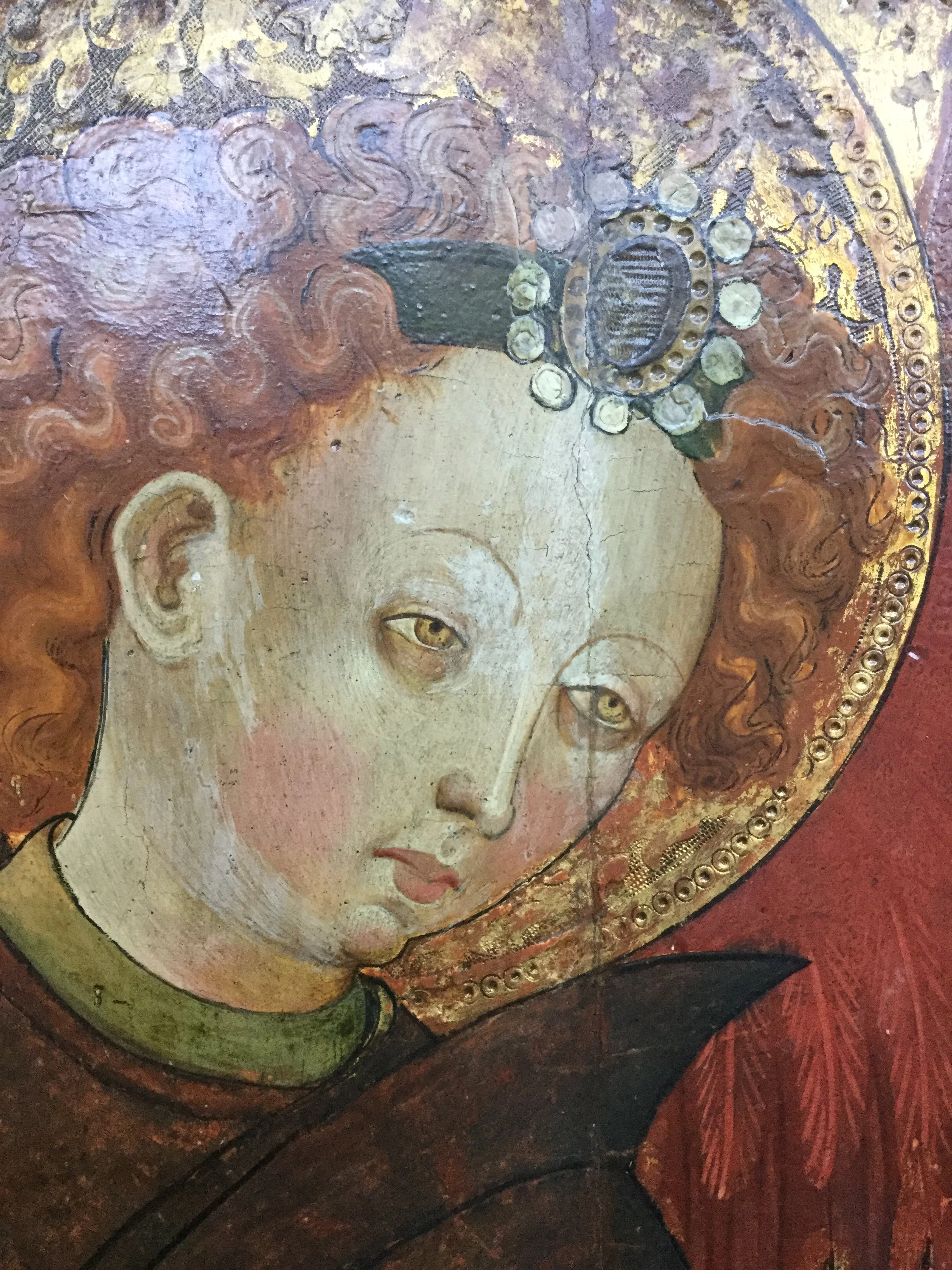 Detail of discolored varnish, repairs and retouching in 15th century panel painting before treatment