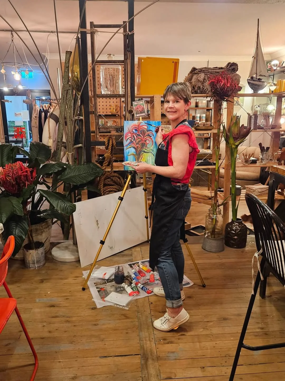 Laura Kneebone, artist, standing at an easel at a Paint & Sip event in Bundeena, Royal National Park, Sydney