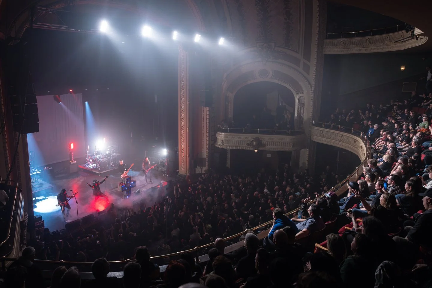 A concert performance with a band playing on stage at the Burton Cummings Theatre in Winnipeg.