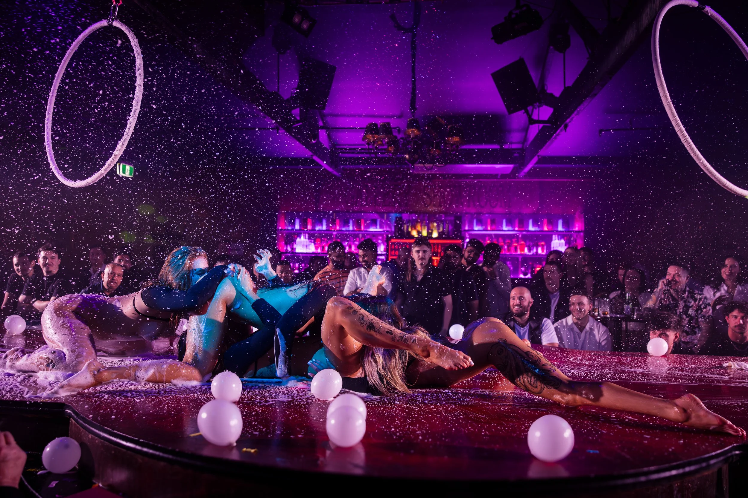 Duo stage performers with hula hoops entertaining the crowd at The Men's Gallery Melbourne strip club