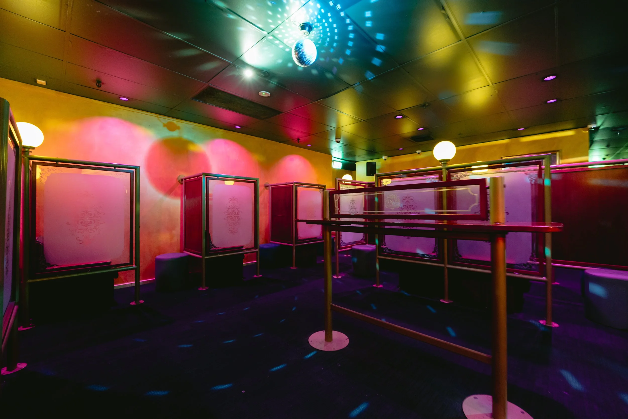 Private booth area with disco lighting at The Men's Gallery Melbourne strip club