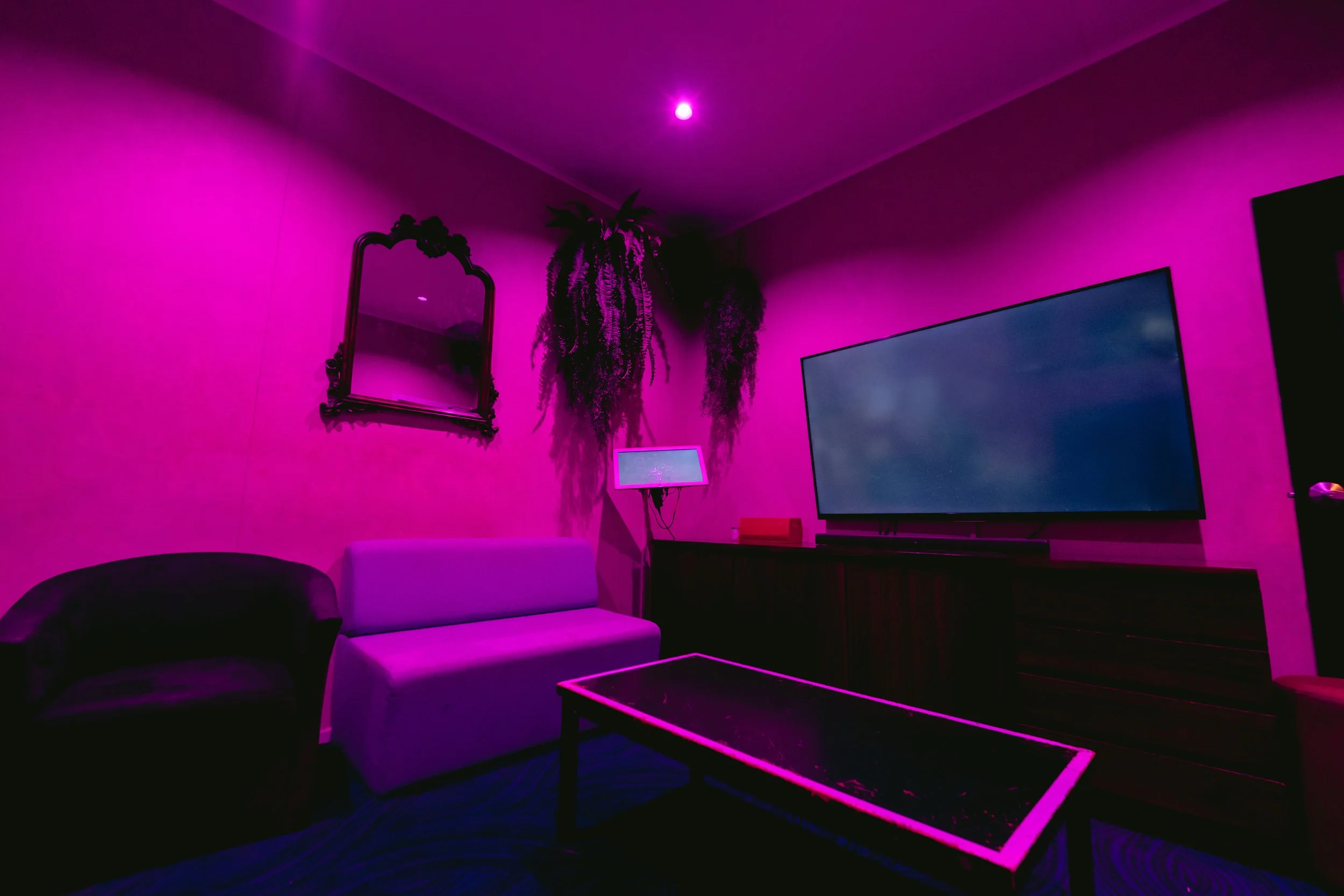 Private VIP lounge room with couch and TV at The Men's Gallery Melbourne strip club
