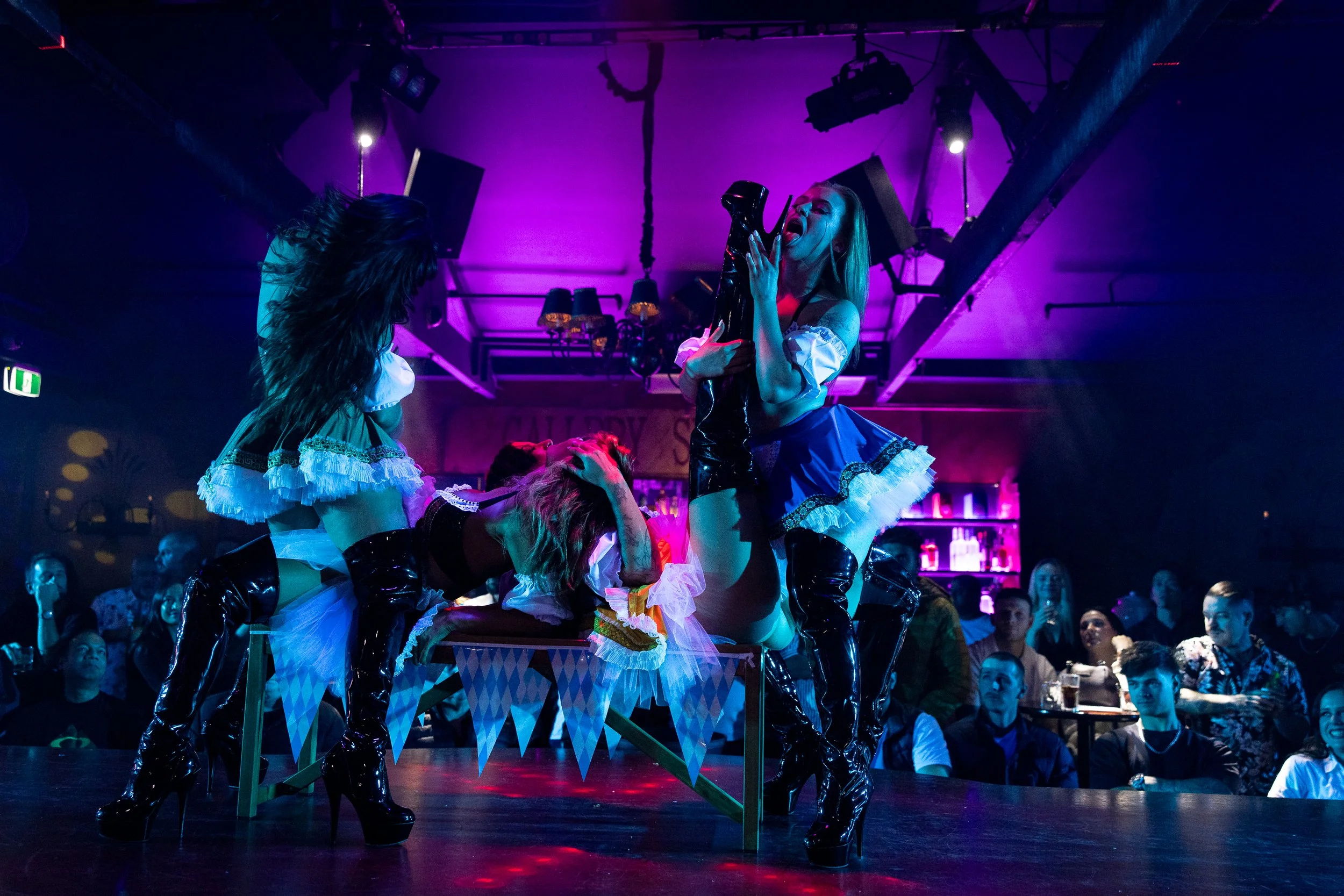 Stage performers in elaborate costumes performing an aerial routine at The Men's Gallery Melbourne strip club