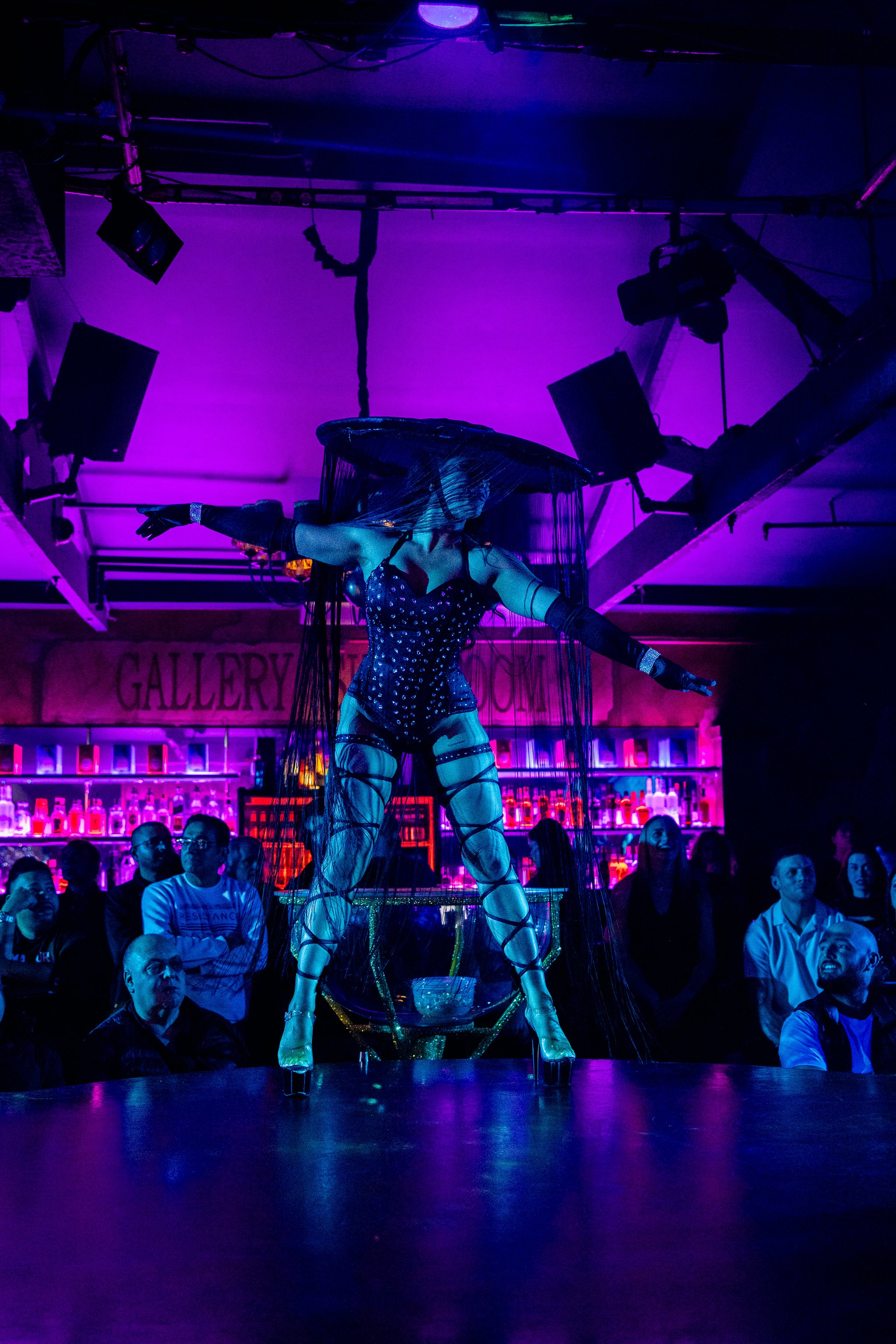 Group stage performers in sparkling costumes during a themed show at The Men's Gallery Melbourne strip club