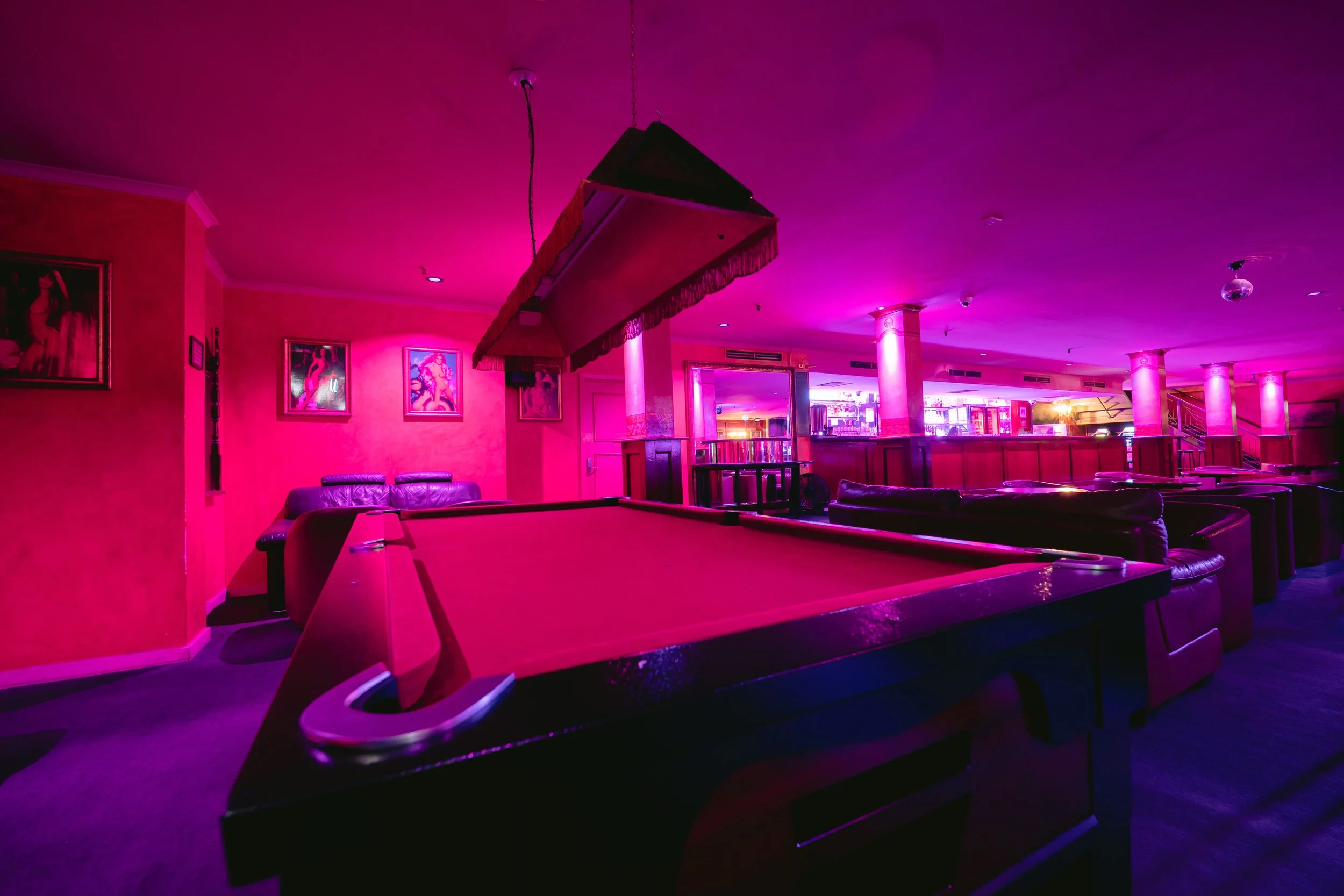 Pool table games area under pink lighting at The Men's Gallery Melbourne strip club