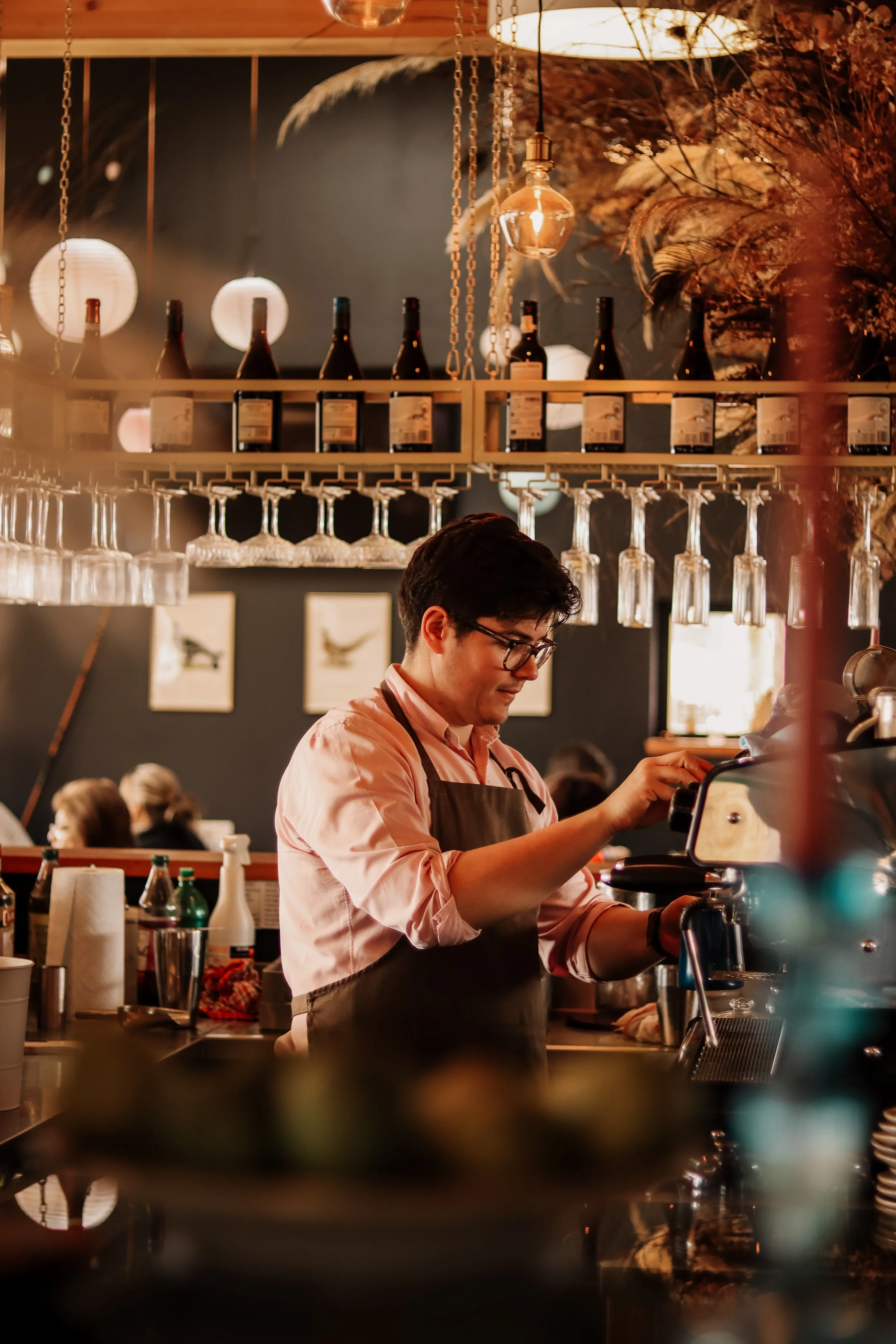 Brand photography of a barista preparing coffee behind the counter at Salt & Salmon, capturing the atmosphere and personality of the café.