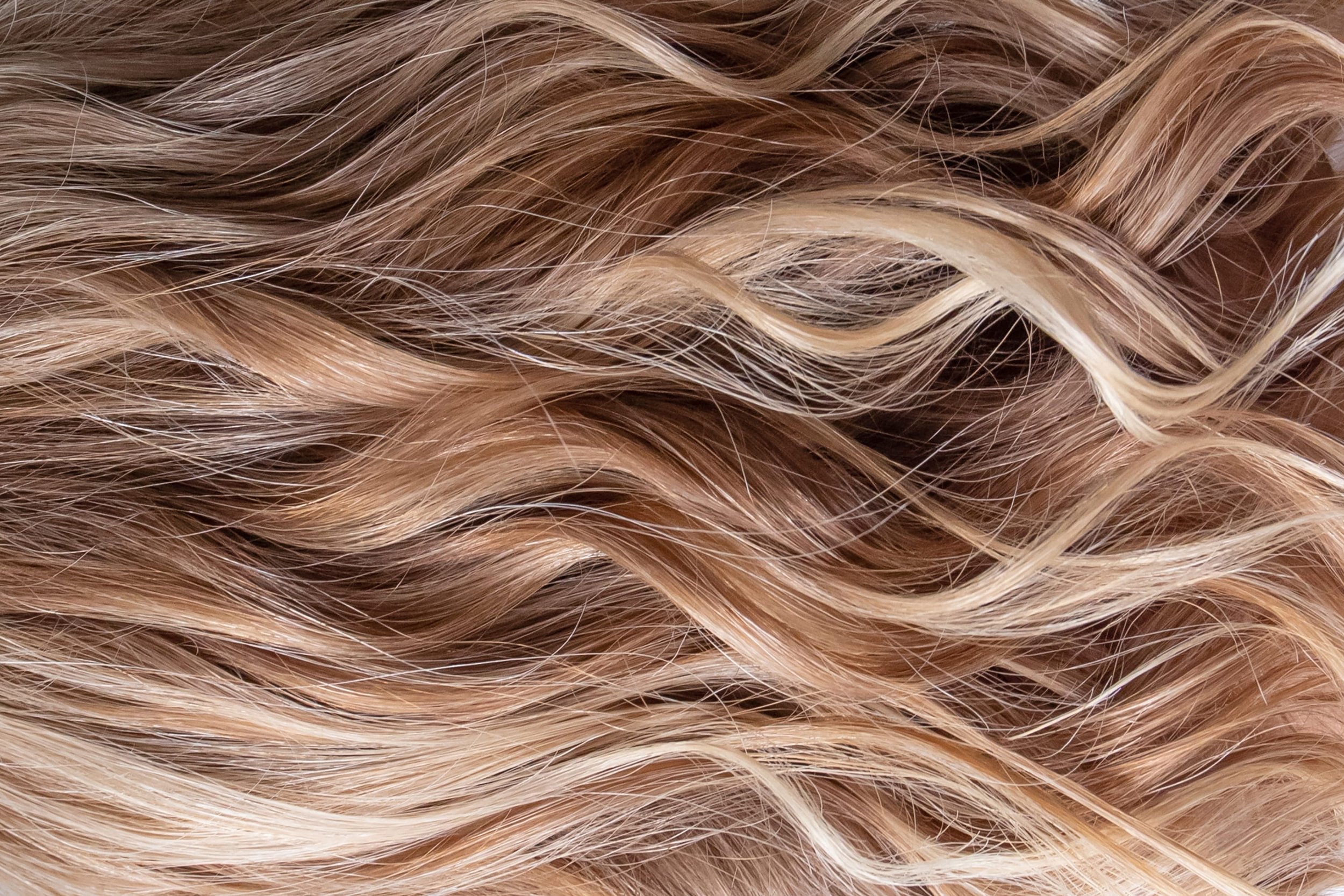 Close-up view of long, wavy blonde hair with highlights.