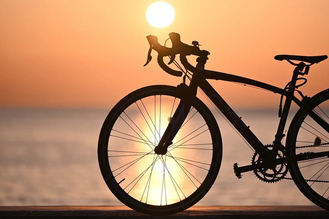 Vélo en silhouette avec un coucher de soleil en arrière-plan sur une plage