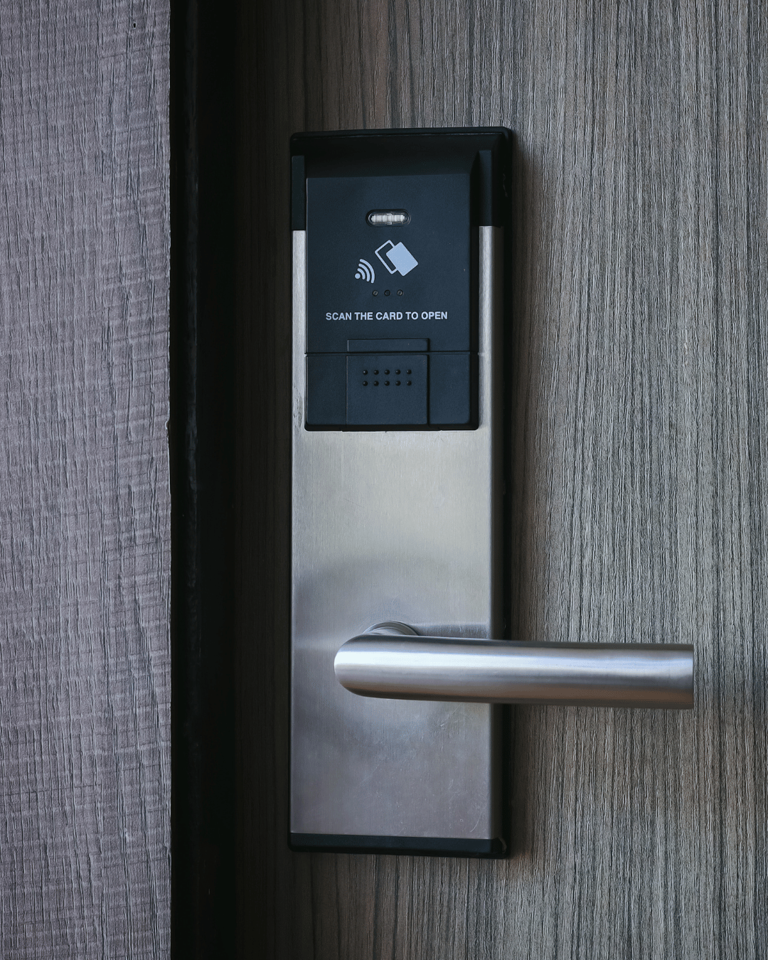 Touchless access control panel with card reader and door handle on a wooden door
