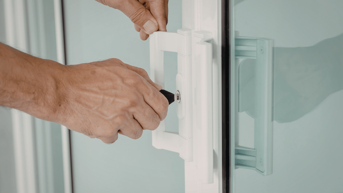 A person using a screwdriver to lock a handle on a white refrigerator door.