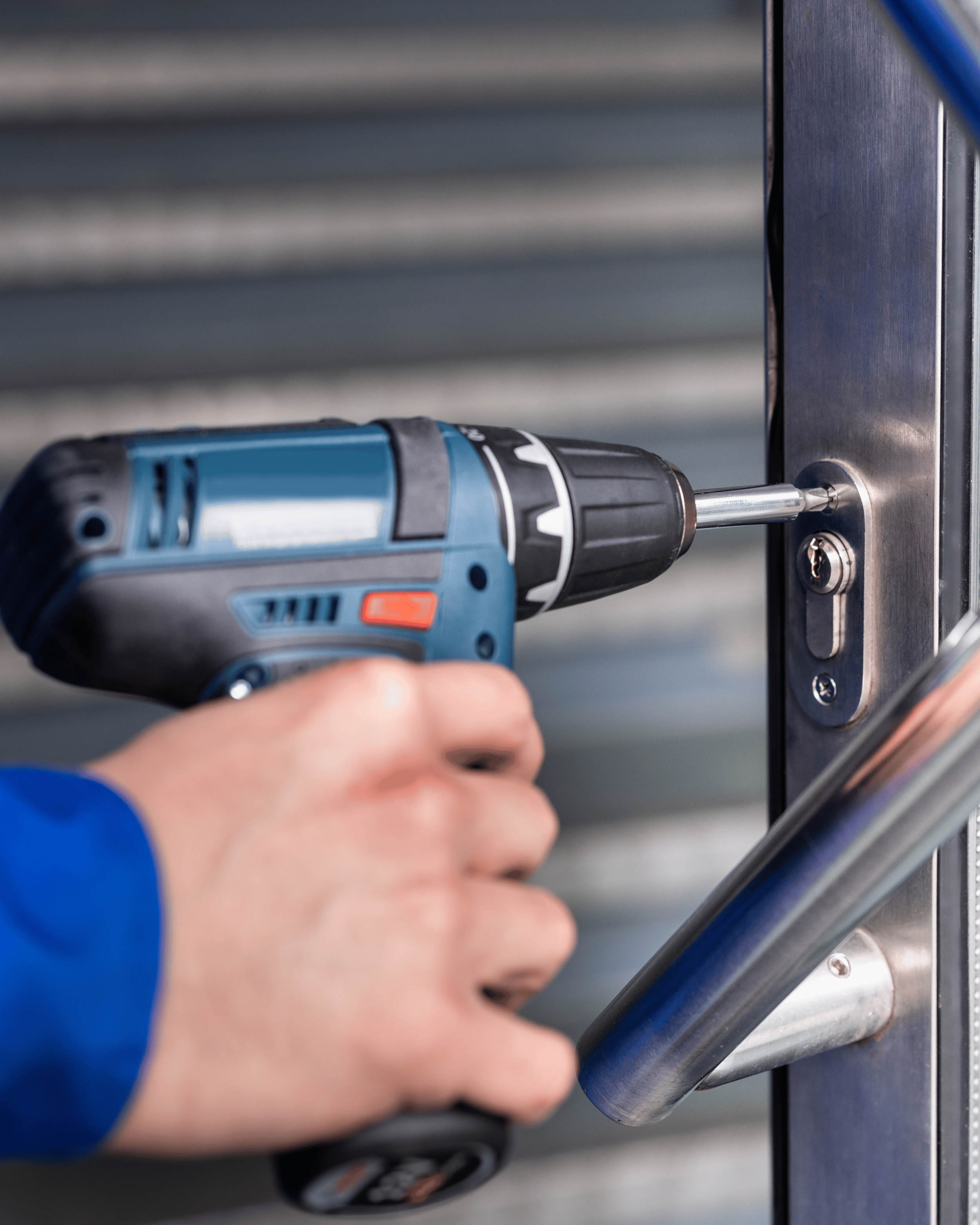 Person using a power drill to lock a door handle.