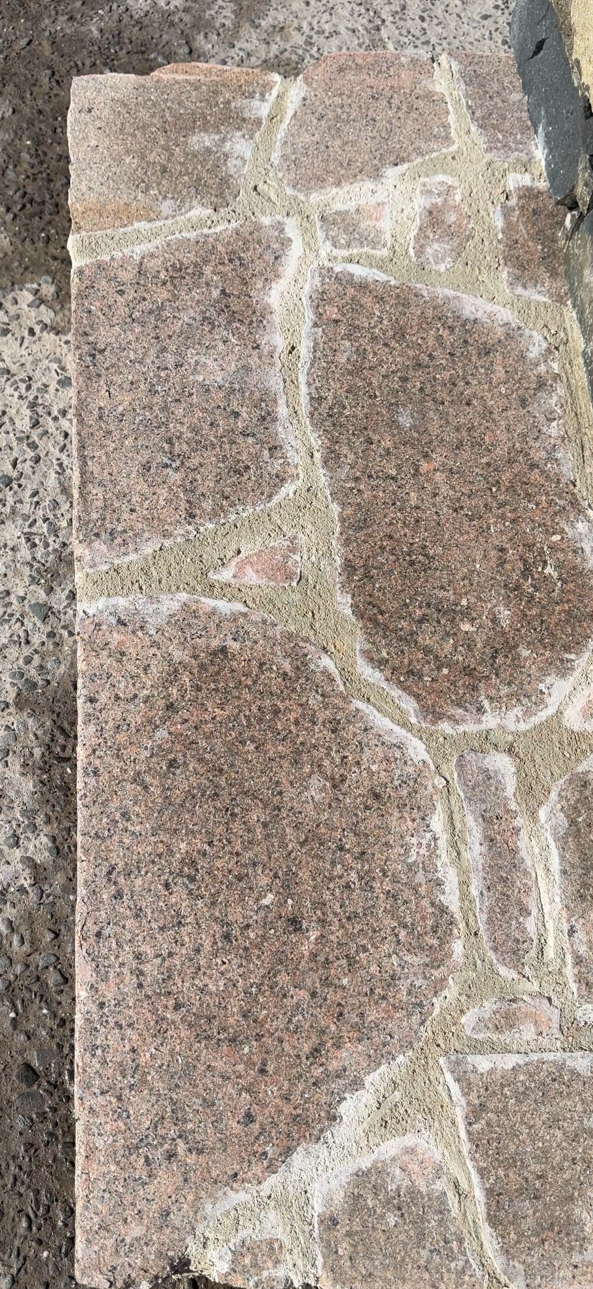 Natural Albury Granite walling stone with mixed grey, ochre and rust colours in a mortared sample wall.