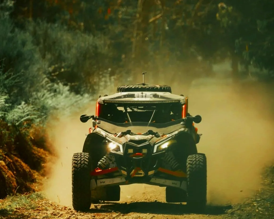 Buggy Can-Am Maverick X3 da Black Buggy Tours fotografado de frente num trilho de terra batida no Gerês, levantando uma cortina de pó na montanha.