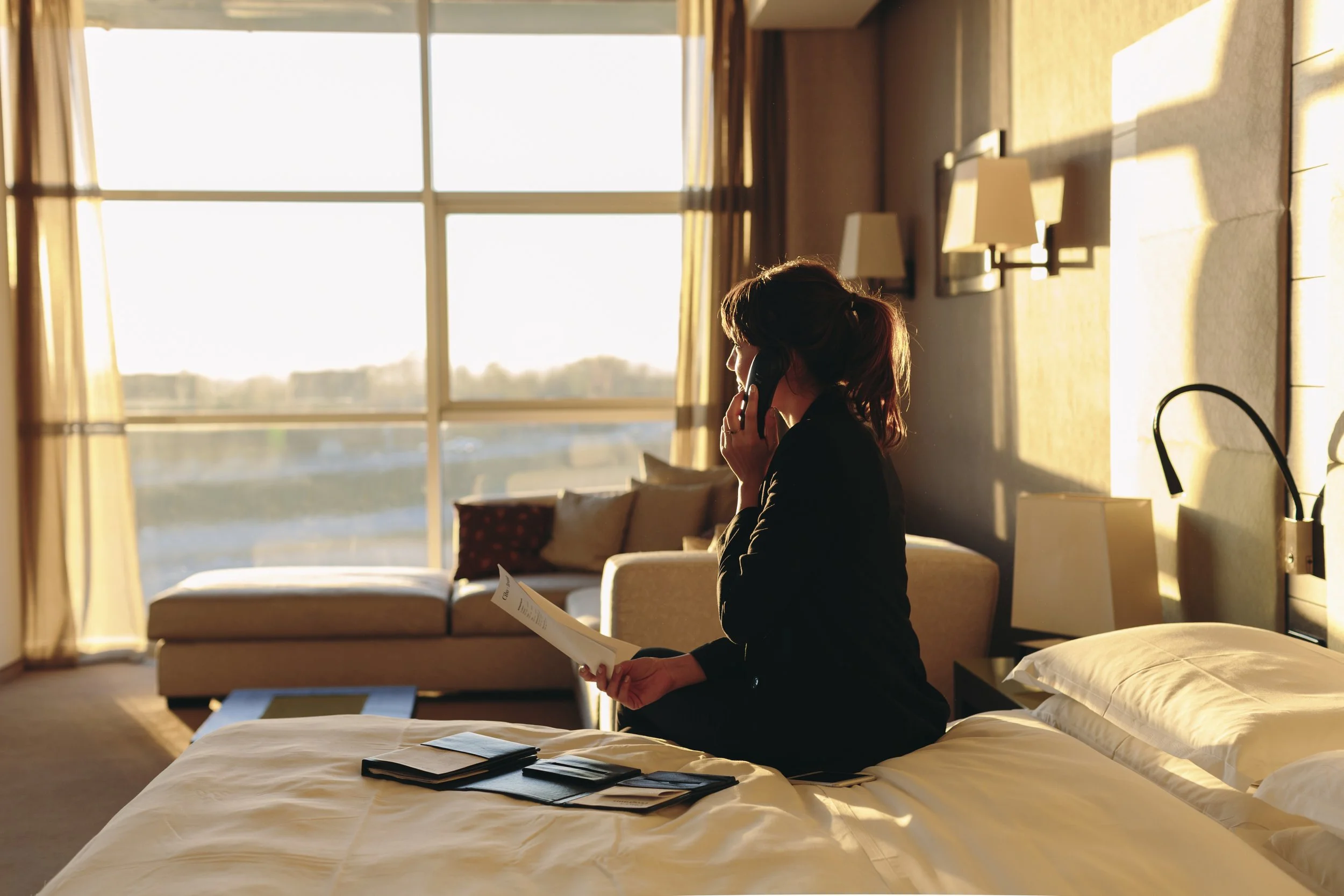 Woman on the phone in a hotel room, representing hotel guest experiences and shoulder season marketing.