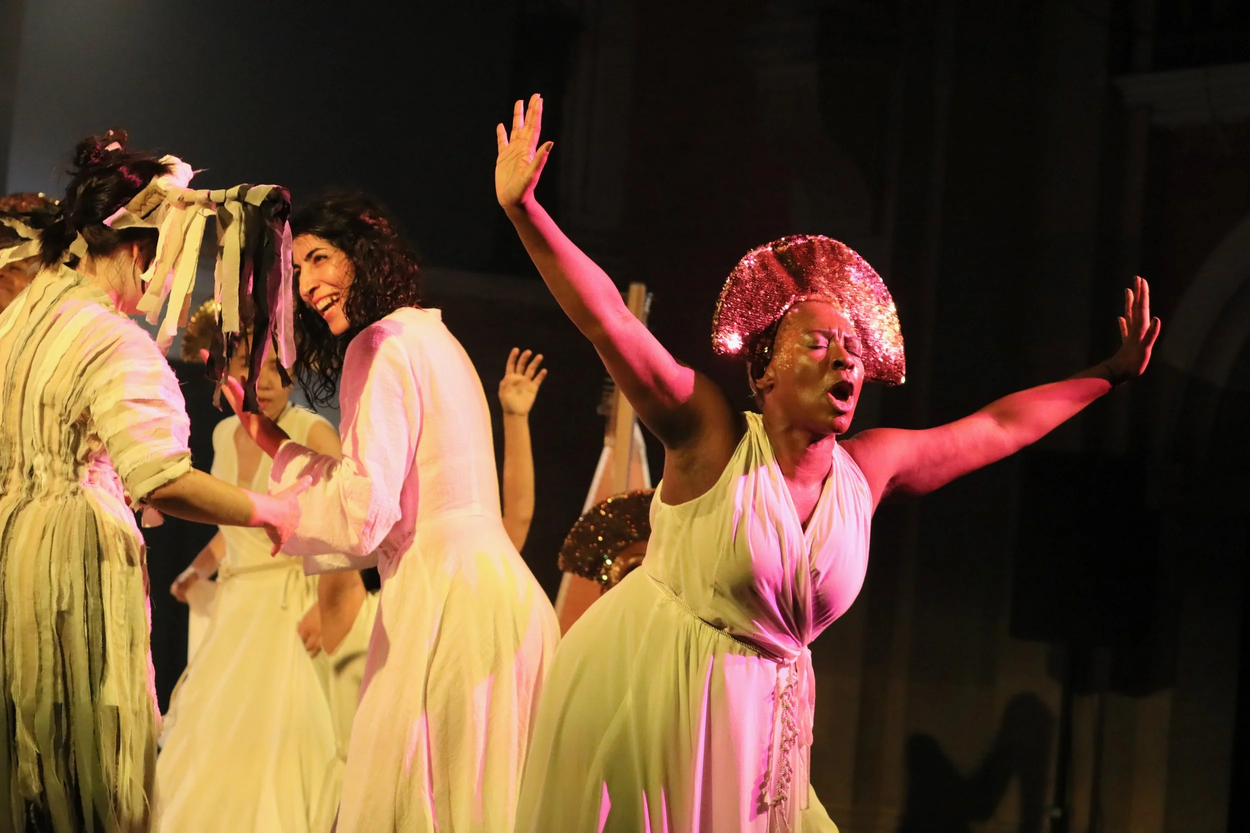 Michelle Cornelius singing and dancing in a white robe and gold headpiece