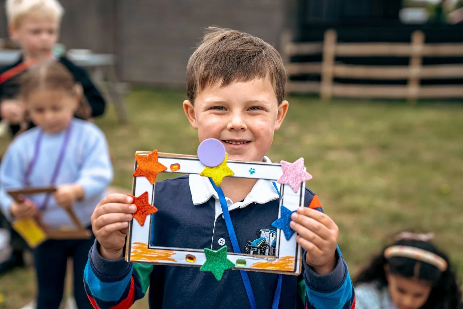 young boy holds homemade photography viewfinder