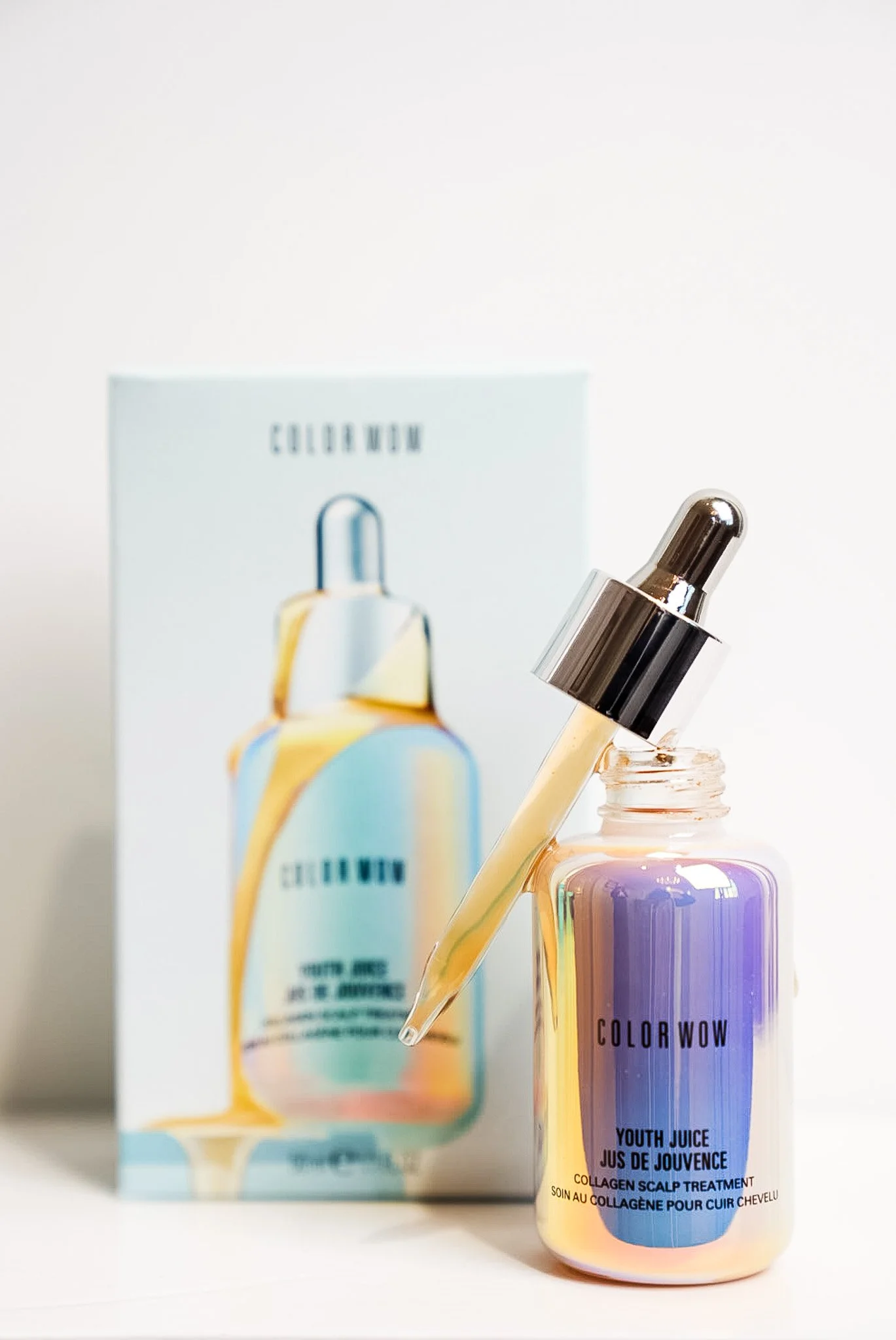 A bottle of COLOR WOW Youth Juice Collagen Scalp Treatment with a dropper resting on the bottle, displayed in front of the product packaging.