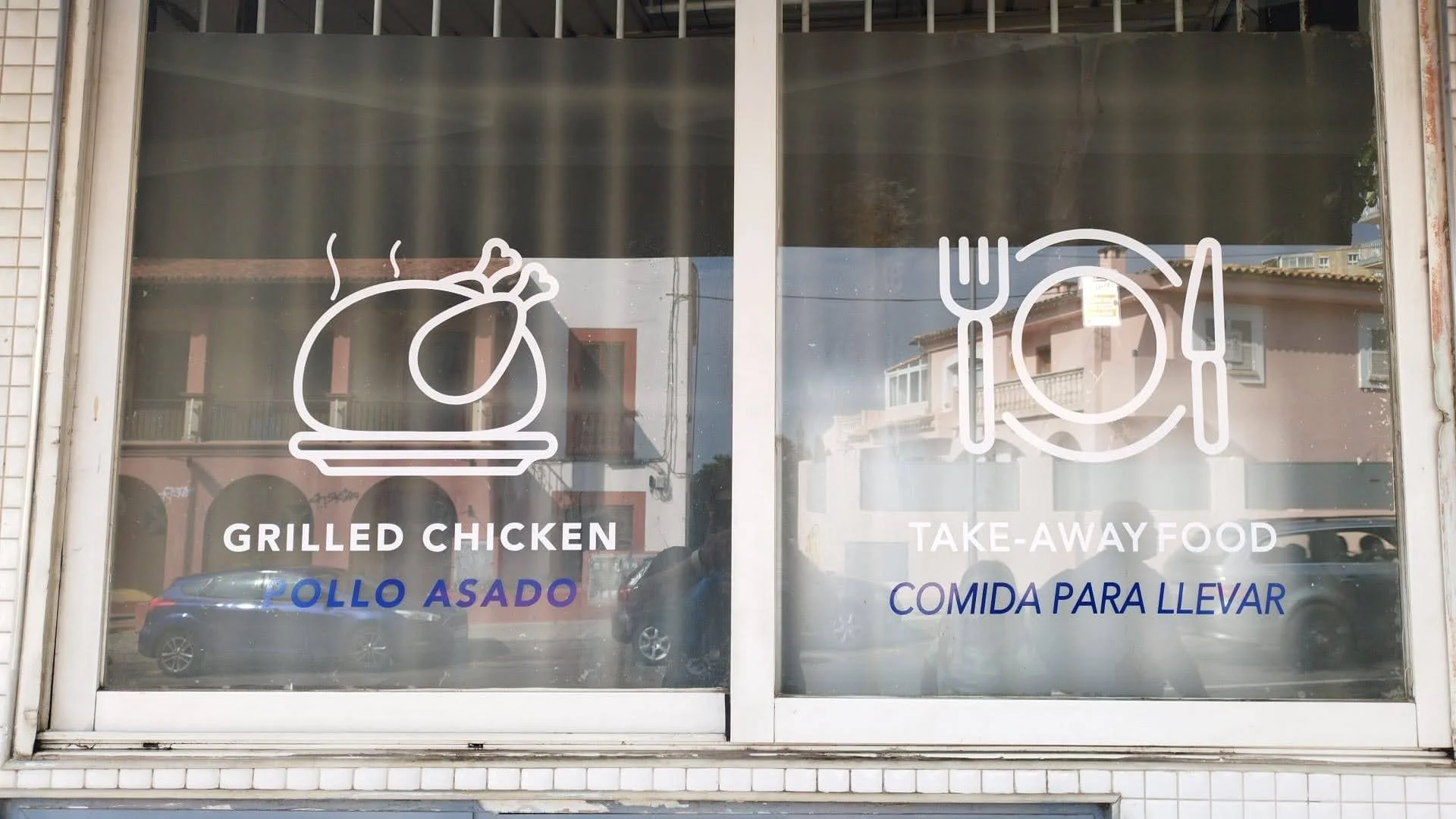 Ventana con iconos de pollo asado y utensilios, con textos en inglés y español que indican comida para llevar y pollo asado.