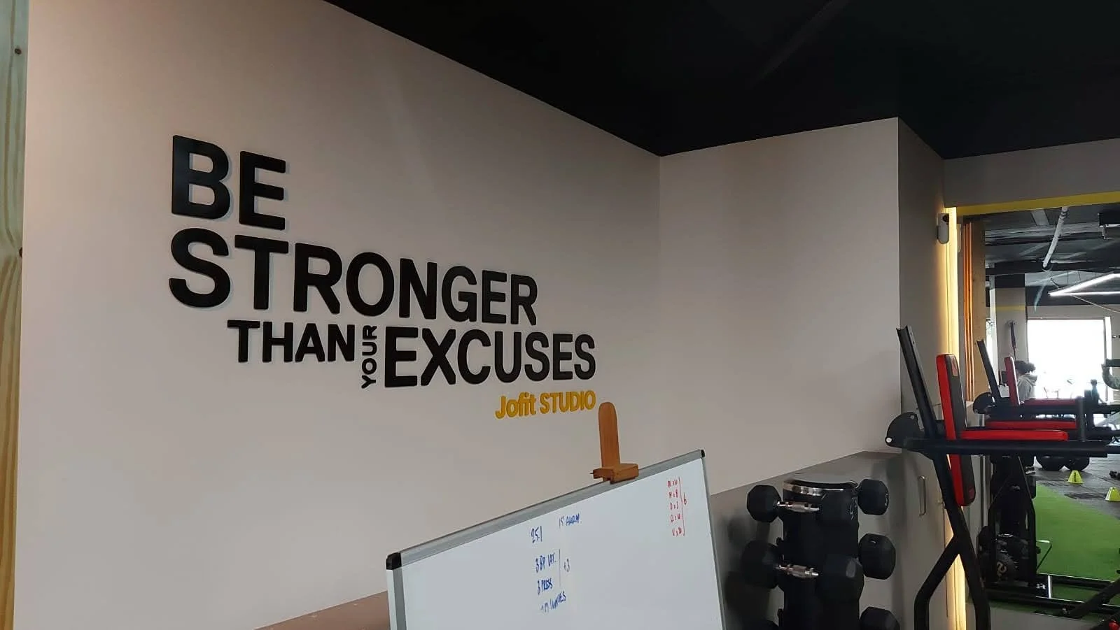 Mural en la pared de un gimnasio que dice 'Sé más fuerte que tus excusas'.