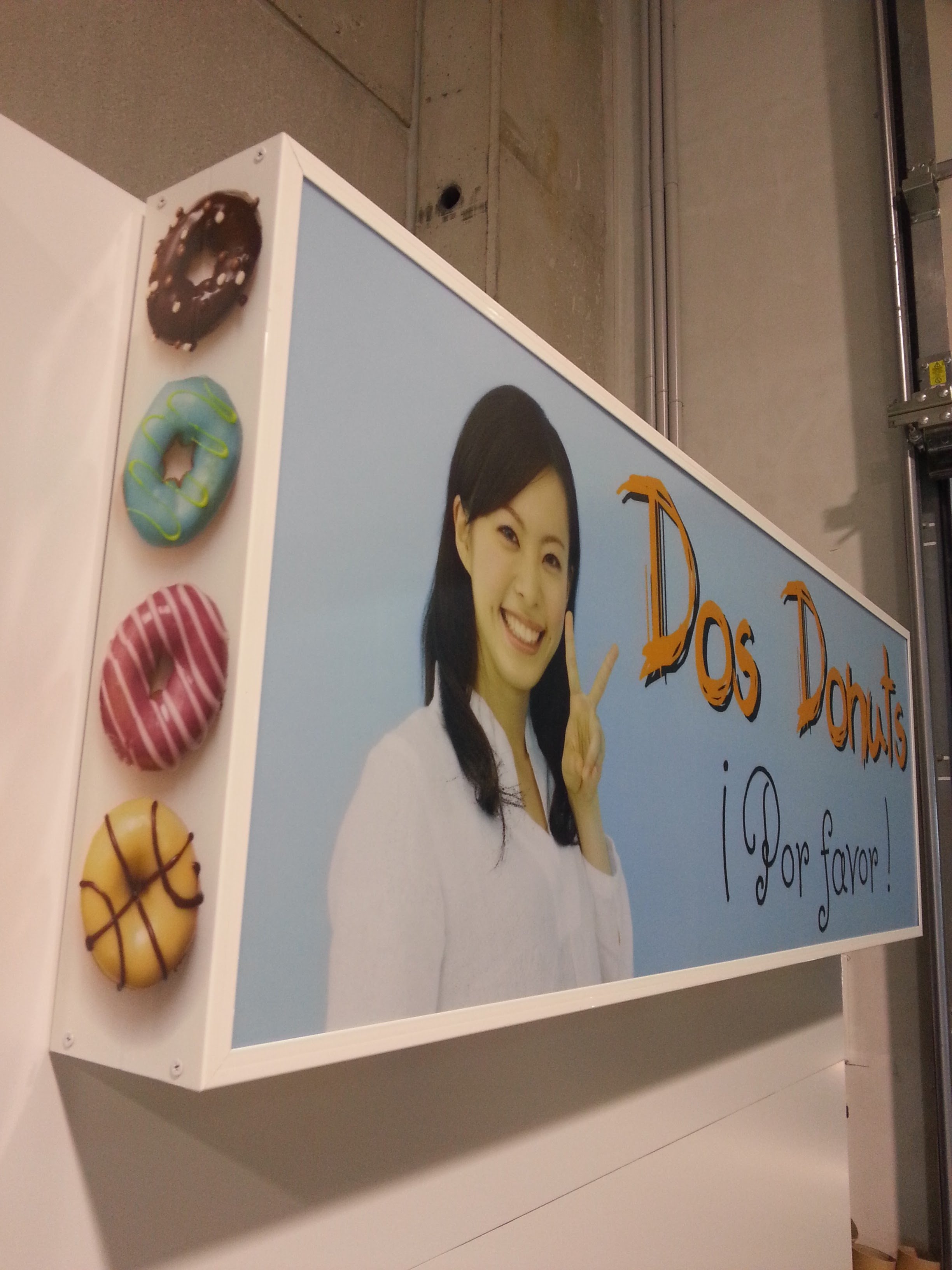 Seis donas de chocolate de diferentes colores y decoraciones en la esquina izquierda de la imagen. A la derecha, hay una publicación con la cara de una mujer sonriendo, haciendo una señal de paz, y parte de un cartel que dice "Dios Pide"