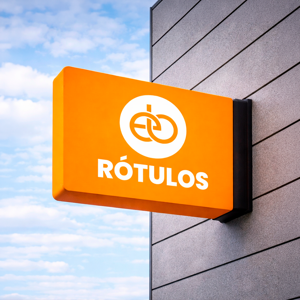 Un cartel naranja con un icono de un par de etiquetas y la palabra 'RÓTULOS' en letras blancas en un edificio con cielo azul y nubes de fondo.