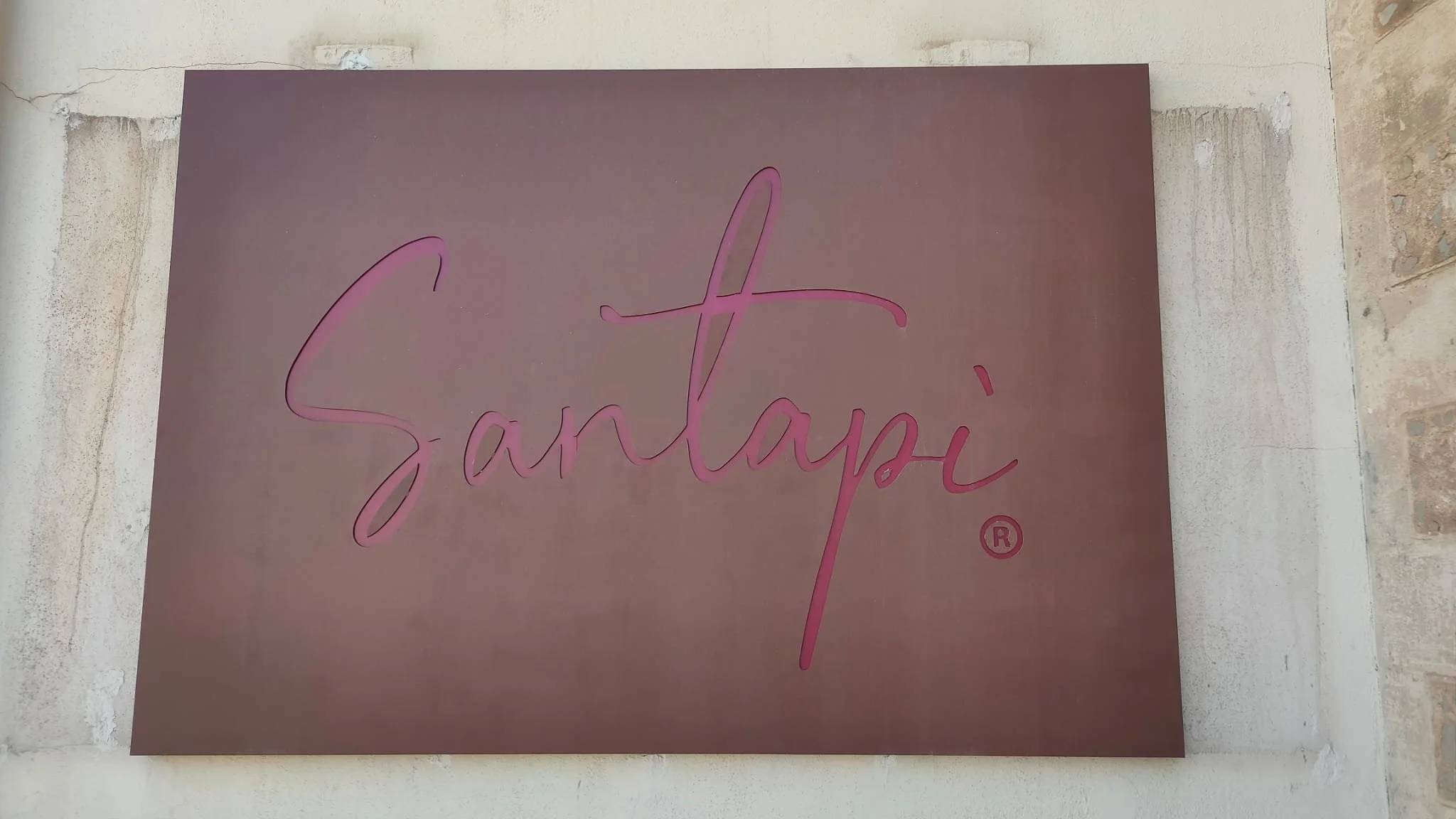 Póster con fondo de color rosa y el texto 'Sandáh' en letras cursivas rosadas.