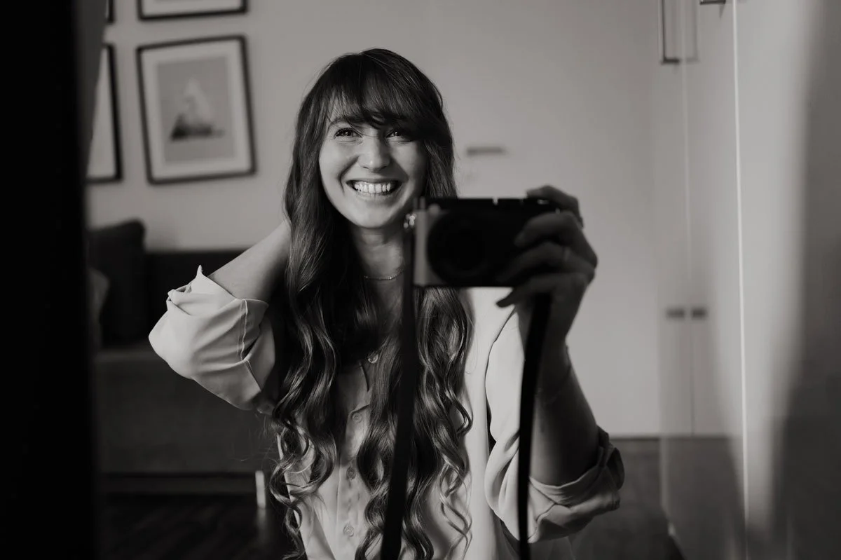 Ein Lächelndes junges Mädchen nimmt ein Selfie mit einer Kamera auf einem Smartphone, in einem Raum mit Bildern an der Wand.