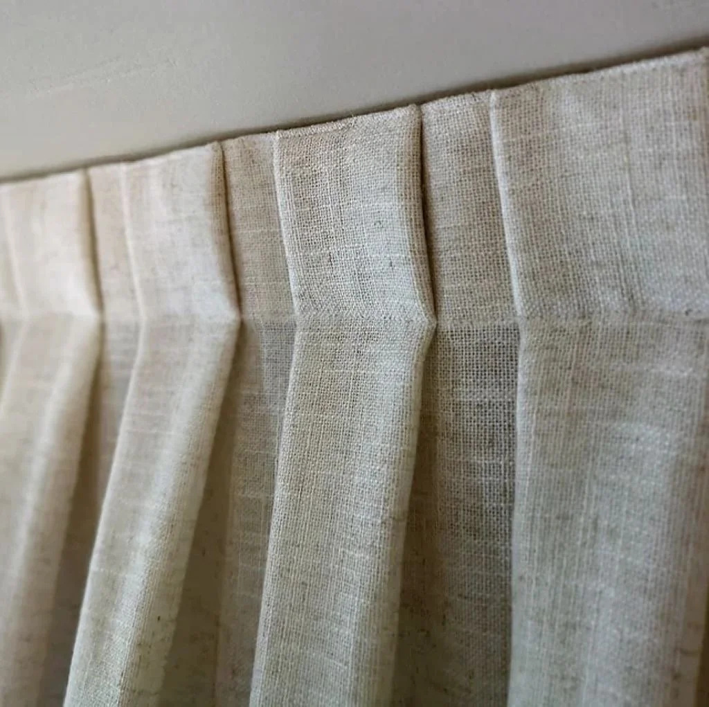 Cortinas de tela clara colgadas en una ventana.