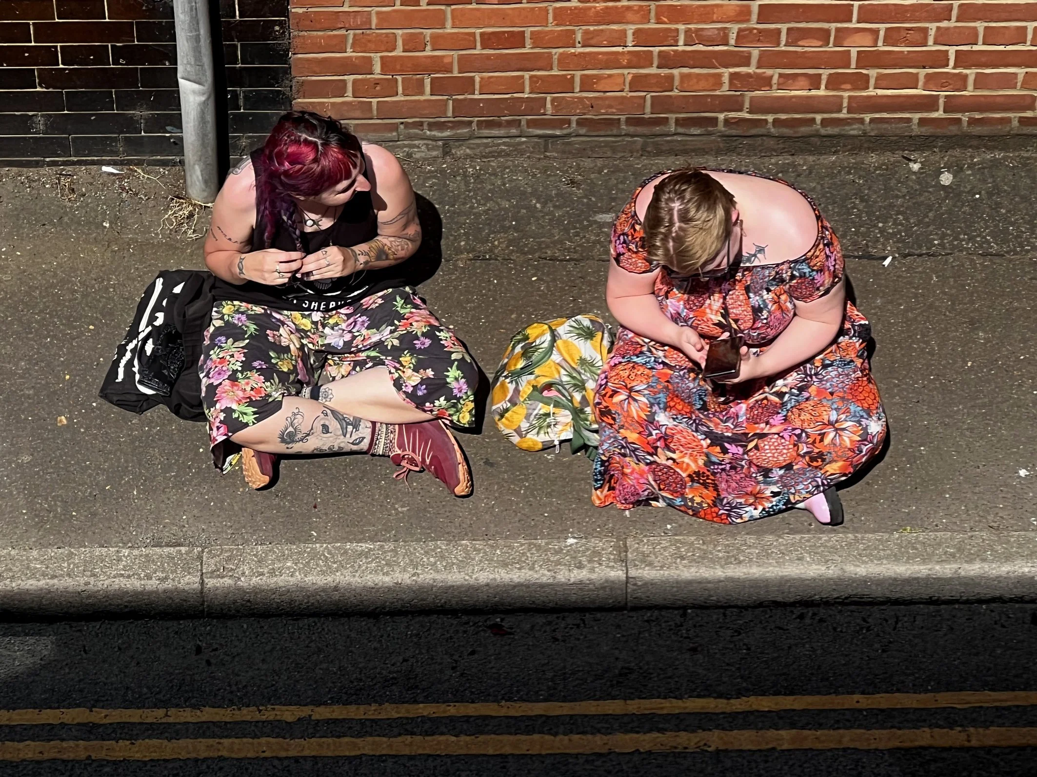 Two women sitting on pavement 3 June 2022.jpg