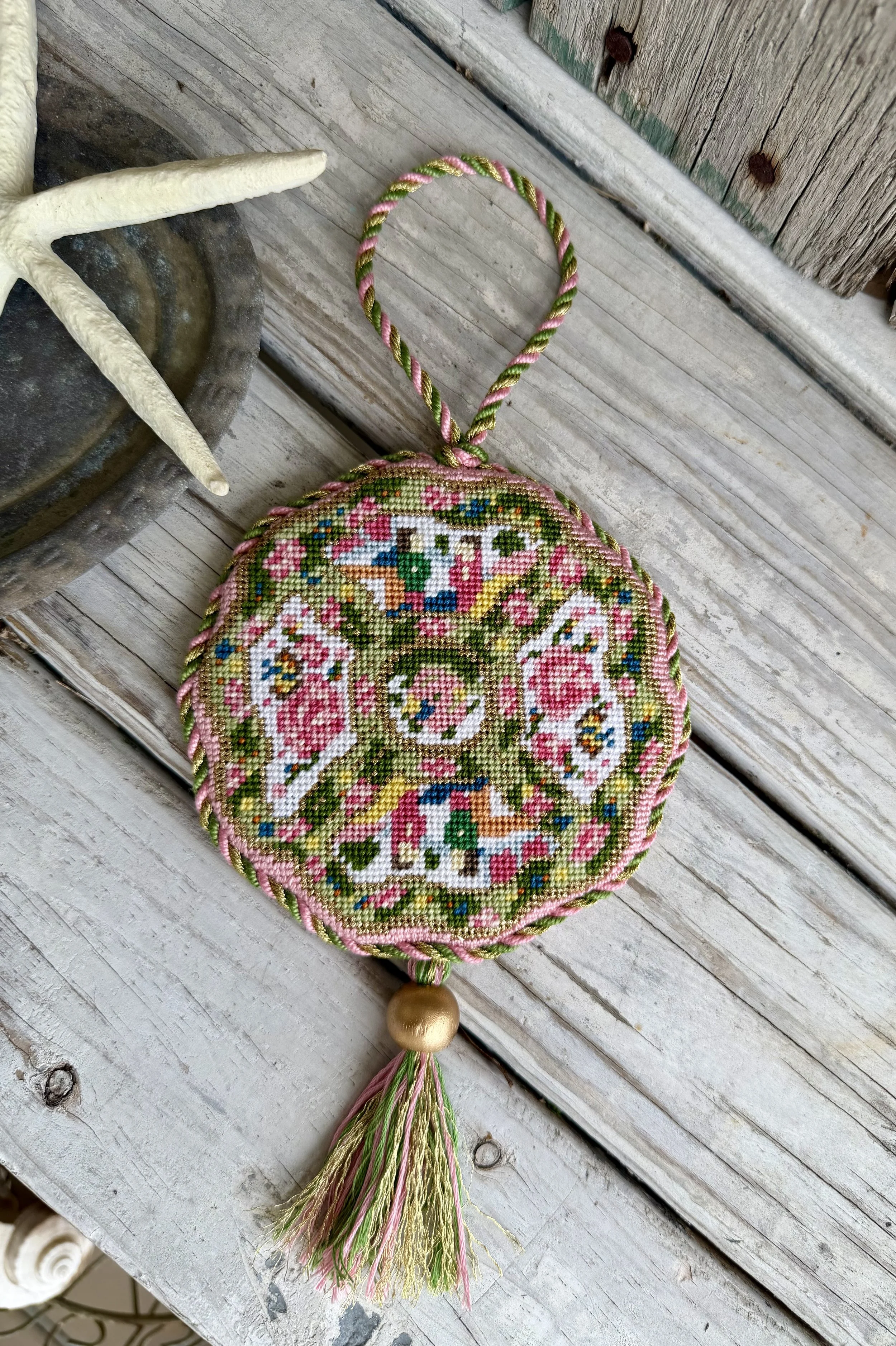 Irregular shaped Needlepoint Ornament of a colorful plate. Custom cording with tassel and gold wood bead. Finished with The Salty Stitchery