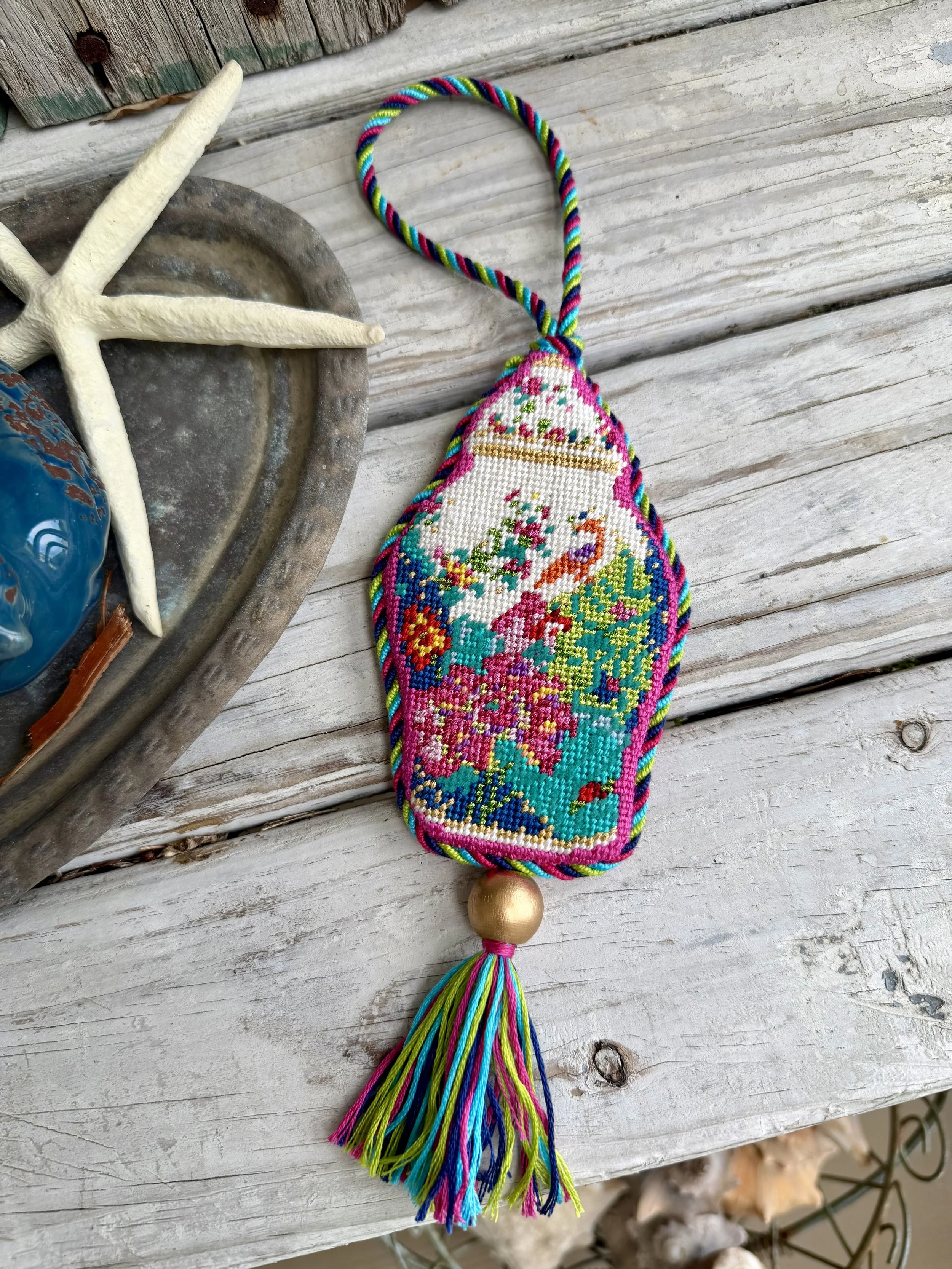 Irregular shaped Needlepoint Ornament of a colorful ginger jar. Custom cording with tassel and gold wood bead. Finished with The Salty Stitchery