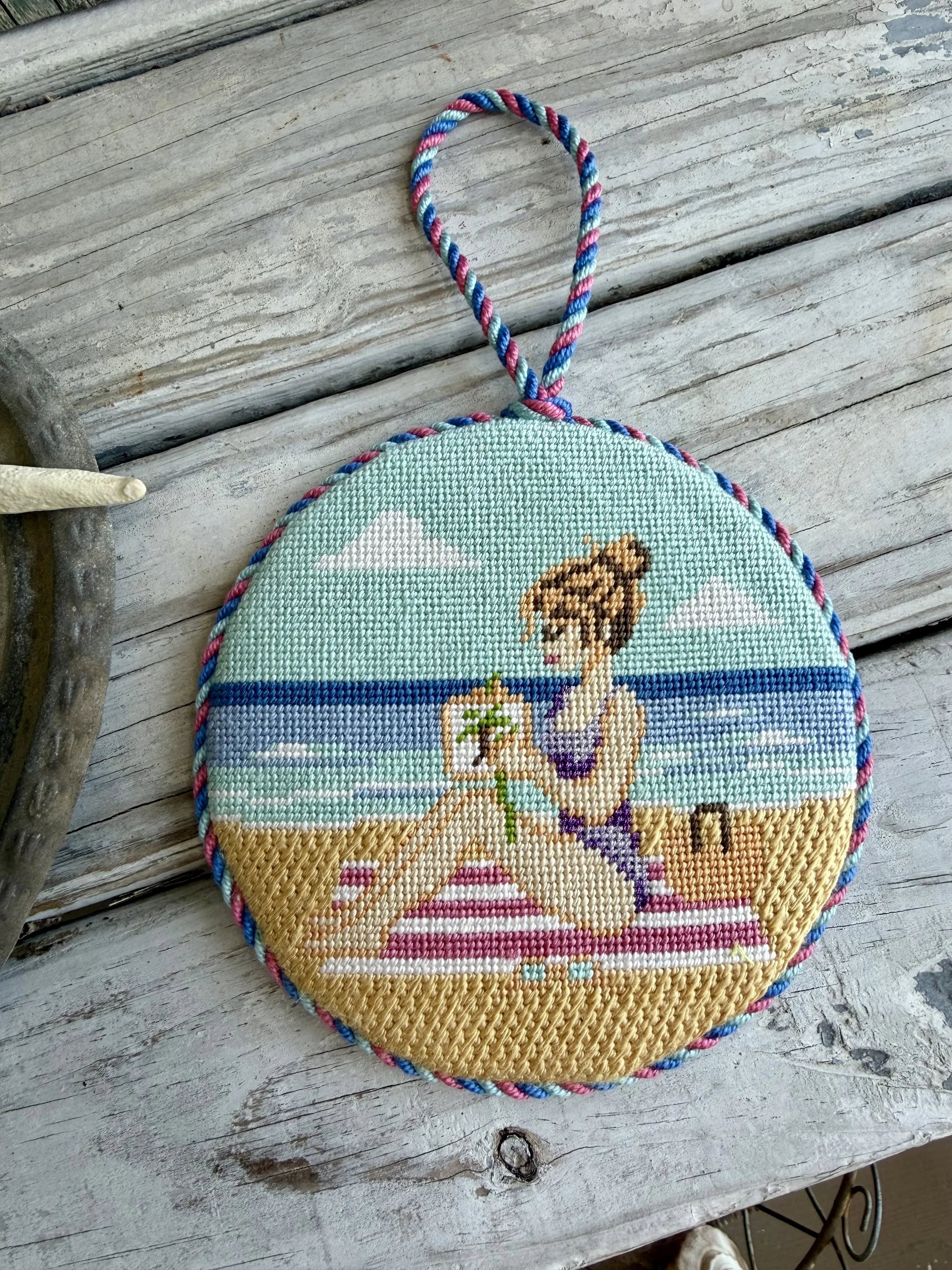 Girl on the beach needlepoint round ornament with custom cording - Finished by The Salty Stitchery