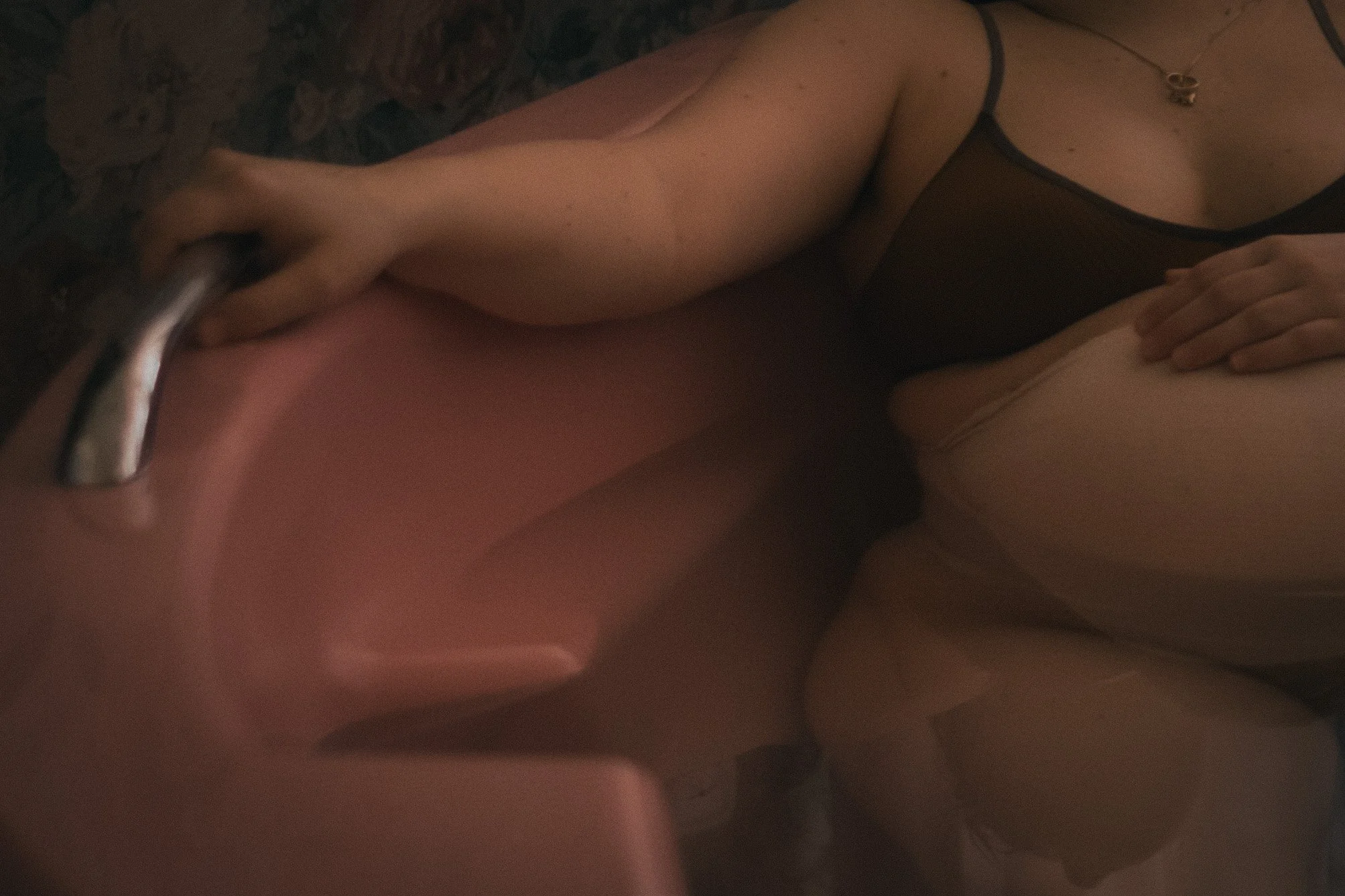 Eine Person steht unter einem Wasserhahn und benutzt die Hand, um Wasser zu schöpfen, während sie auf einer Oberfläche steht.