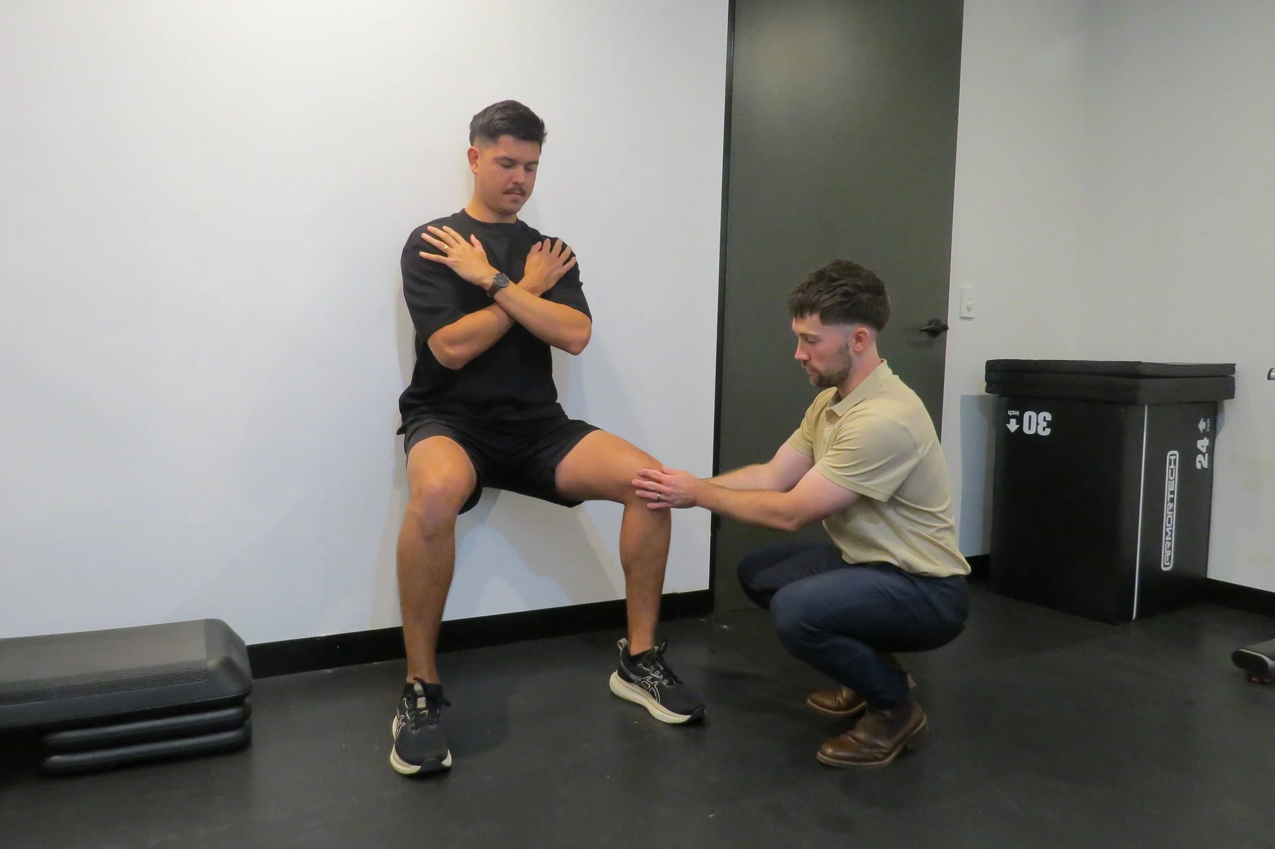 Exercise physiologist reviewing and assessing a knee injury for rehabilitation