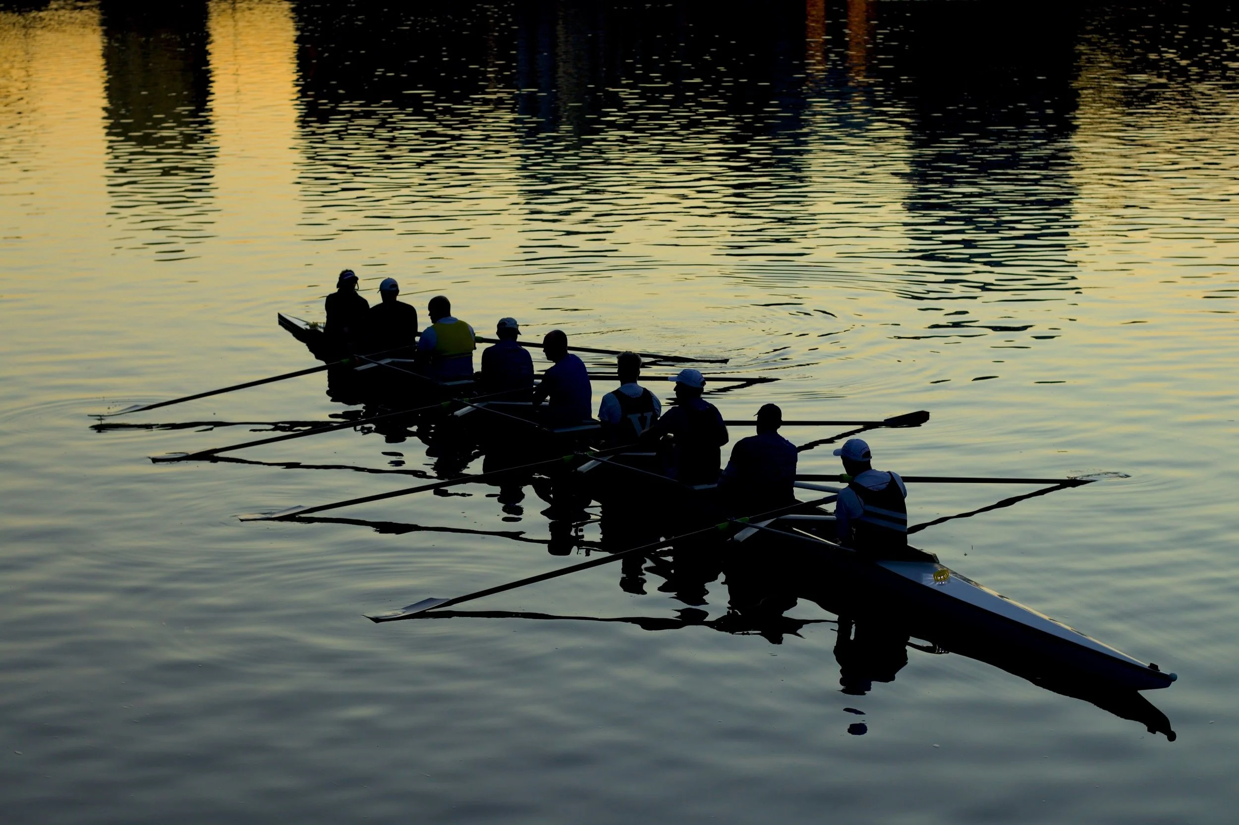Nine men in a rowboat on calm waters