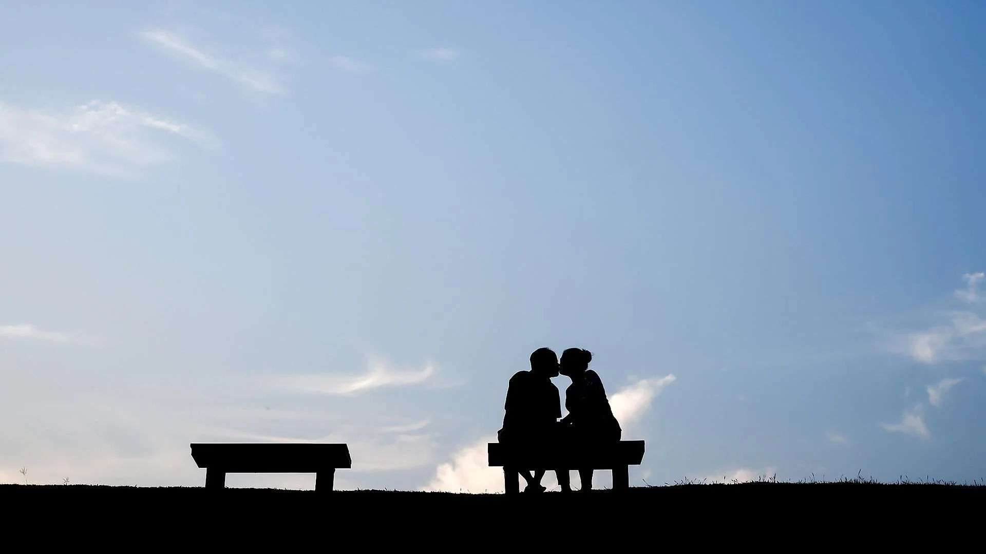 Couple kissing on a bench