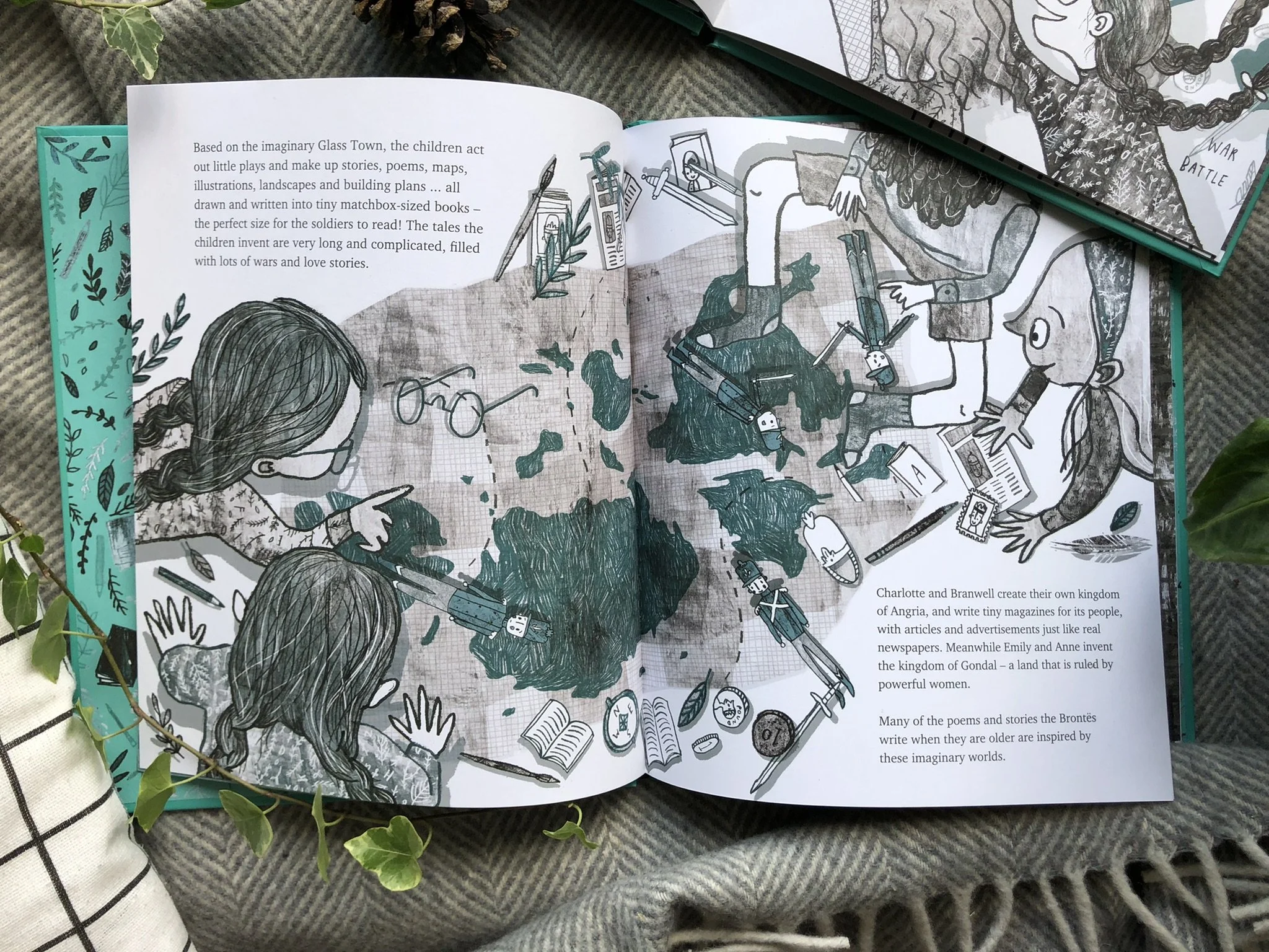 An open illustrated book featuring children creating their own imaginary kingdoms, with detailed drawings of children, nature, and fantasy elements on the pages.