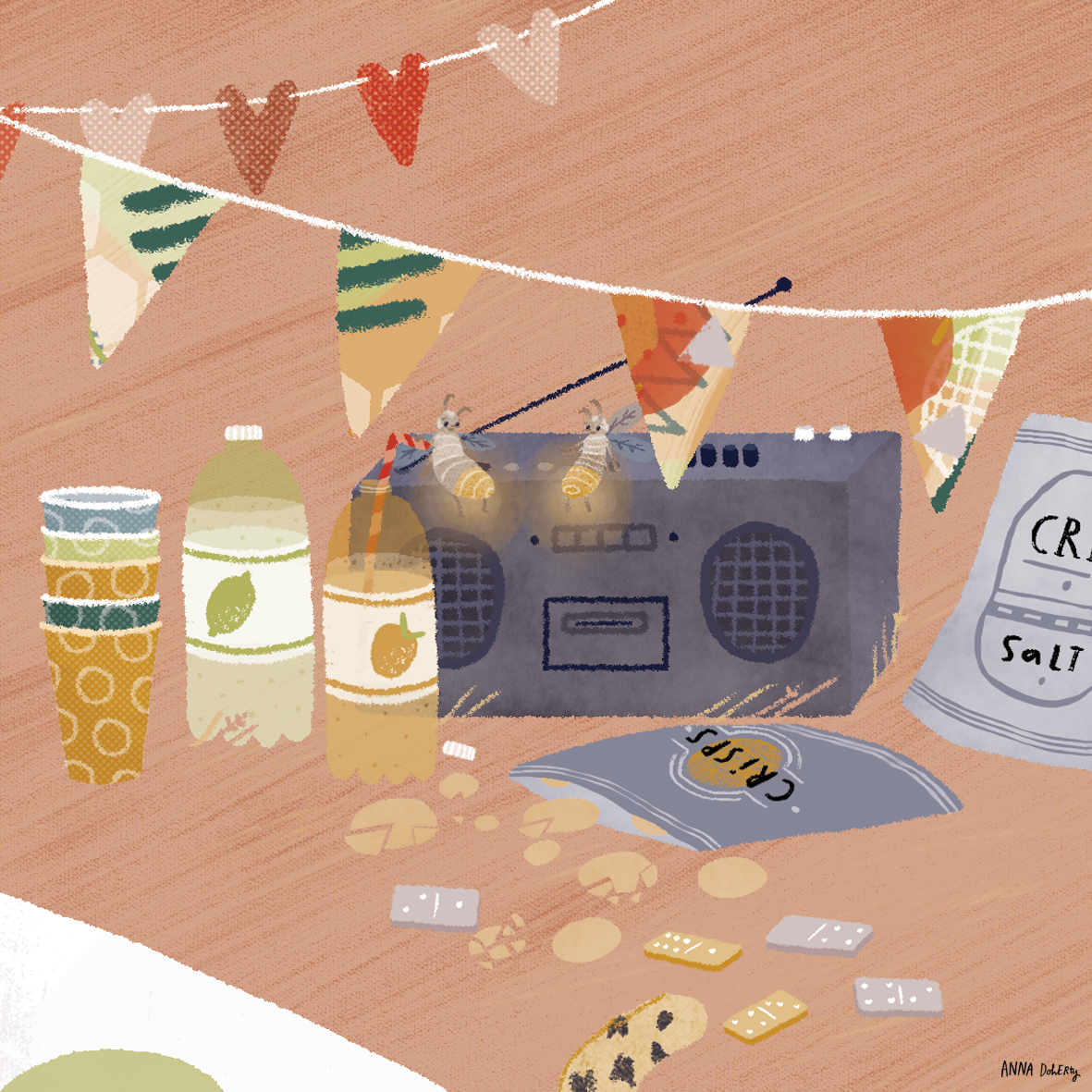 A collection of snacks, drinks, and a speaker on a table, decorated with colorful bunting flags and two bees perched on a string, with spilled chips and cookies.