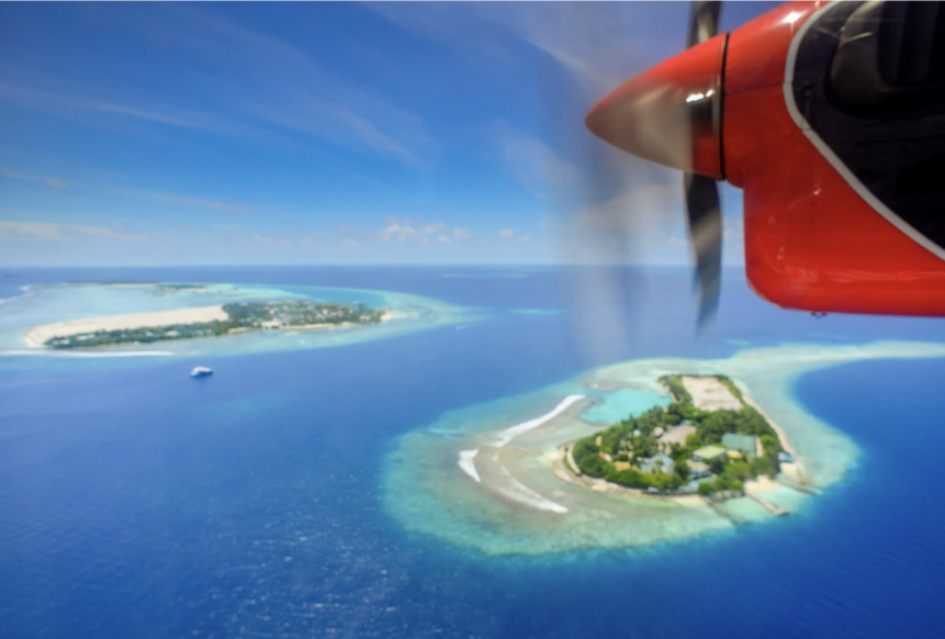is the holiday worth the jetlag - image of a plane over a tropical island paradise, this article talks about what jetlag is.