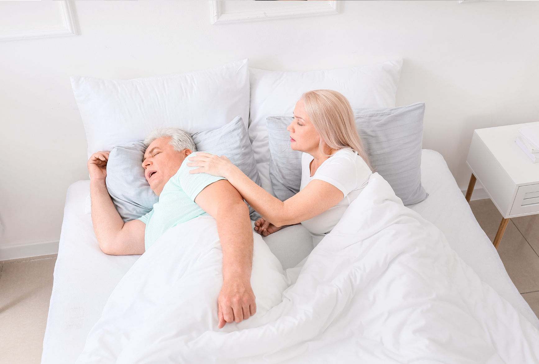 Concerned wife hearing her husband gasp in his sleep