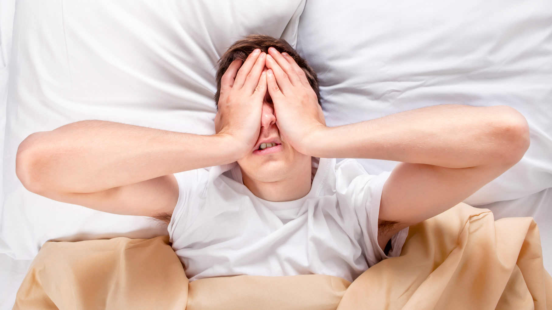 tired man waking up feeling he has not slept, likely because he is suffering from sleep apnoea symptoms