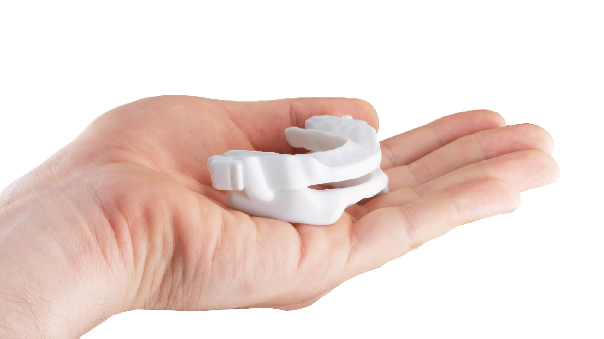 An oral appliance held in a patient's palm, to show how small it is