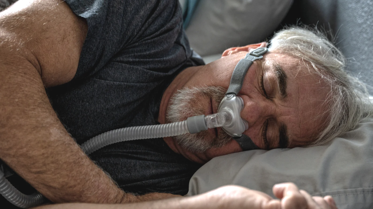 man sleeping with CPAP mask for his sleep apnoea