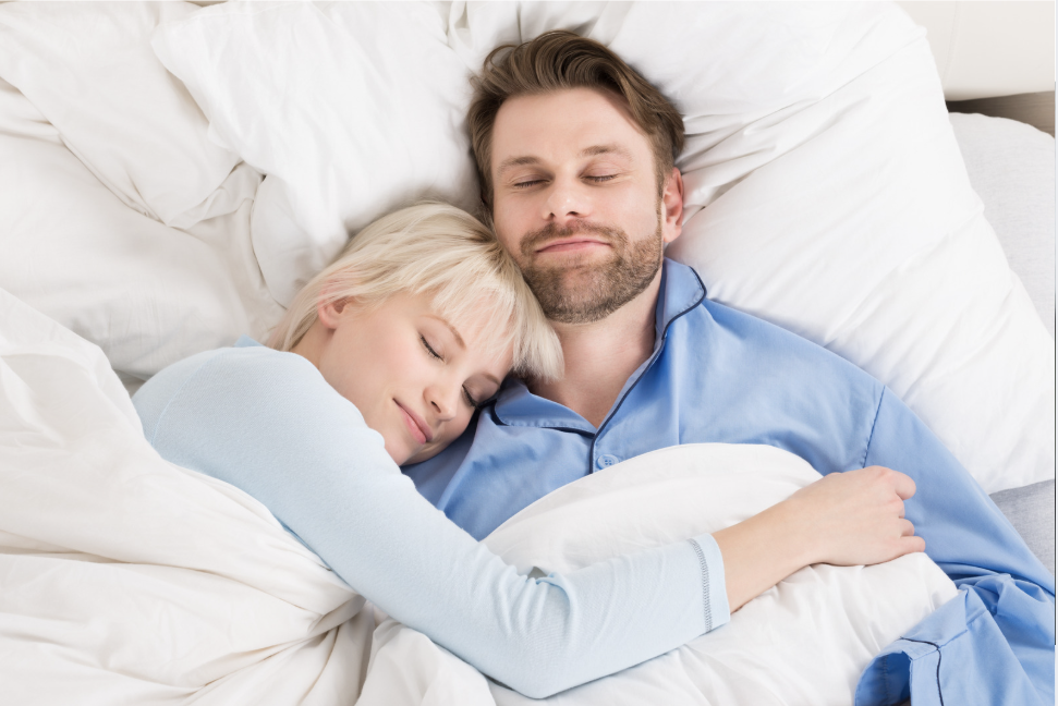 happy couple sleeping comfortably in bed because they don't have to deal with the husband is snoring, or because the wife is snoring any longer as when snoring is solved, everyone sleeps better