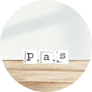 The word 'Pass' spelled out with letter tiles on a wooden surface.