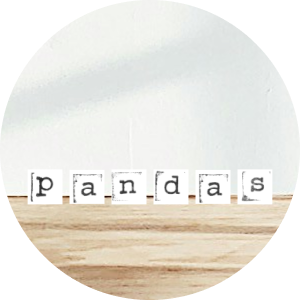 Wooden surface with a paper spelling out the word 'pandas' in individual letter tiles.